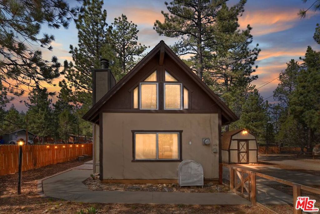 Turnkey and fully furnished, this beautifully remodeled Big Bear cabin is the ideal mountain getaway or short-term rental investment. Situated on a desirable corner lot with easy access via HWY 38, the home features an open-concept living area with vaulted A-frame ceilings and a cozy wood-burning fireplace perfect for winter nights. The updated kitchen includes stainless steel appliances, a built-in wine rack, and stylish newer flooring. Two loft-style sleeping areas provide flexible accommodations with a queen bed and full-size futon, making it easy to host overnight guests. A washer and dryer are included, offering convenience for both full-time living and guest stays. Outside, enjoy peaceful mountain views, vibrant sunrises and sunsets, and clear starry nights from the spacious Trex deck (installed in 2021), complete with outdoor dining space. Additional upgrades include a new fiberglass front door (2024), a newer roof (approximately six years old), updated electrical (2021), a new water heater (2022), and a storage shed for added functionality. The property also includes a First American Home Warranty seller-paid and valid through February 2026 for extra peace of mind. Located just minutes from ski resorts, Big Bear Lake, hiking trails, the Village, and the zoo, this cabin offers easy access to all the area's top attractions. Whether you're looking for a peaceful mountain retreat or a ready-to-rent Airbnb, this turnkey cabin offers the perfect blend of comfort, convenience, and income potential in the heart of Big Bear.