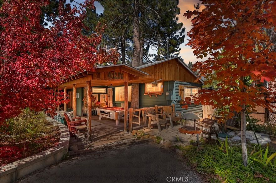 Welcome to 40256 Dream Street — a timeless Big Bear cabin full of rustic charm ~ This classic 3-bedroom, 2-bath home sits on a generous 5,330 sq ft lot and hasn’t been on the market since 1998 ~ Originally built in 1950, the property boasts vintage mountain character ~ Inside, this home blends natural light with warm wood and log accents, a floor-to-ceiling stone fireplace, and clawfoot tubs in both bathrooms — including an ensuite with elegant slate wainscoting and a stackable washer and dryer ~ The kitchen features tile countertops, and opens to a cozy dining area, with nook ~ Step outside to enjoy a covered porch with recessed lighting, great for relaxing evenings under the pines ~ The pea-graveled wraparound driveway provides expansive parking, with potential RV and boat storage ~ Whether you’re searching for a serene mountain retreat, a full-time residence, or a vacation rental investment, this cabin on Dream Street delivers the quintessential Big Bear experience — quiet, peaceful, and full of character.