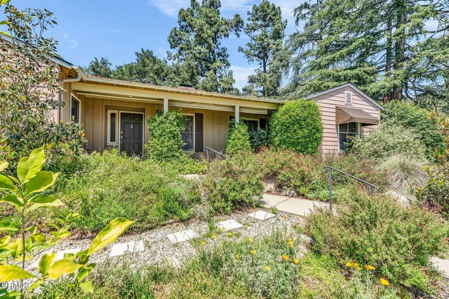 Great price adjustment. Nestled in the foothills of Altadena near scenic hiking and nature trails, this updated traditional home blends timeless charm with a modern open layout. Originally designed by Robert E. Williams--an early partner in the notable firm Train & Williams--and first built by W. E. G. Saunders, the home offers both architectural significance and everyday comfort. At its heart is a dramatic great room with vaulted ceilings, a fireplace, French doors to the backyard, and large windows that fill the space with natural light. The chef's kitchen features a center island, breakfast bar, stainless steel appliances, and granite counters. Additional highlights include a formal living room with wall-to-wall bookcases and fireplace, an oversized dining room, and a spacious primary suite with walk-in closet, spa tub, and travertine finishes. Two more generously sized bedrooms and 1.5 additional baths offer flexibility for guests or work-from-home. Hardwood floors, crown molding, recessed lighting, and thoughtful updates run throughout. A finished 550 sq ft two-car garage includes an EV charger. Surrounded by mature trees with views of the mountains, this home is a peaceful retreat in a coveted foothill location.