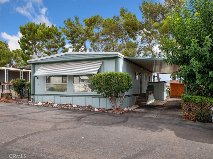 Tucked away in a welcoming 55+ Apple Valley community, this manufactured home is move-in ready and full of surprises. Step inside to a spacious great room with a formal dining area, fresh laminate flooring (installed just 6 months ago), and plenty of natural light. The kitchen offers not one but two pantry closets, and appliances are included — washer, dryer, fridge, and stove — so you can settle in with ease. The home features two generously sized bedrooms: one with an en suite bath, the other with a sitting area, dual closets, and access to a private deck with sweeping valley and desert views. Outside, you’ll find a fenced yard, two storage sheds (one with electricity and a foundation), and a deck perfect for enjoying those breezy desert evenings under the pine trees. With a new water heater, well-kept condition, and even some furniture included, this one is truly turn-key.