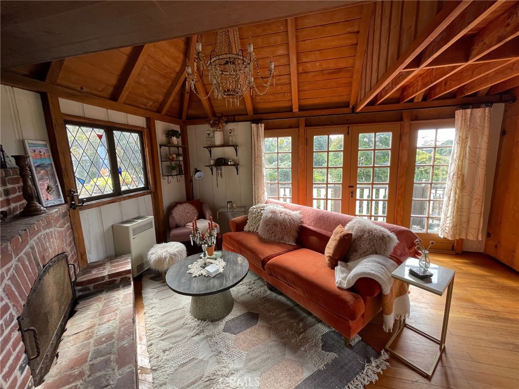 Go back in time and relax within this vintage Tudor cottage home built in 1936. This property is situated in the heart of the Laguna Village District on a quiet cul-de-sac street. It is within walking distance to local beaches, fine dining restaurants, shopping, art galleries, and coffee shops. This hillside escape has balconies, private deck areas, and an upper landing area with spectacular ocean views. Enjoy the natural serene surroundings and cool ocean breeze. The home interior is fully furnished and features rustic open wood beam vaulted ceilings, hardwood floors, wood paneled interior walls, chandeliers, stained glass windowpanes, and a wood burning red brick fireplace. On-site private laundry facility is available. Street parking only. (Note: This home is being offered unfurnished.)