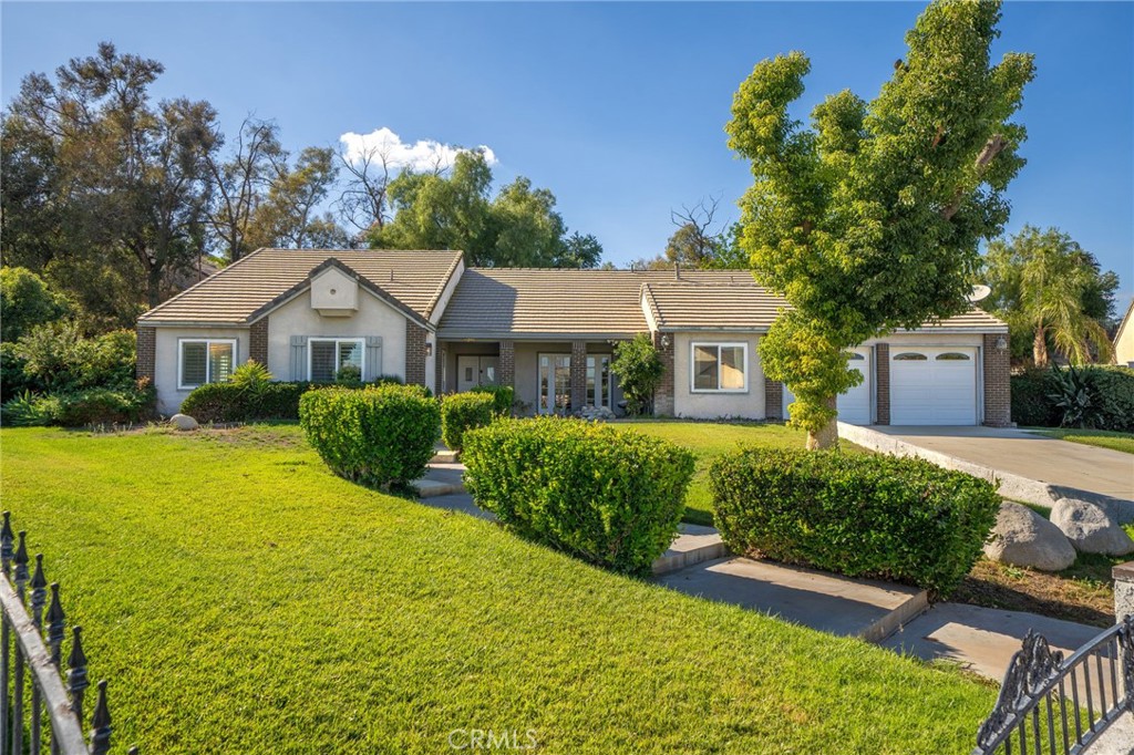 Welcome to 11292 Cadbury Drive, a spacious single-story retreat nestled in one of Riverside’s most desirable neighborhoods. This beautiful home features 5 bedrooms, 2.5 bathrooms, and approximately 2,810 square feet of living space, all situated on an expansive 24,394-square-foot lot that offers endless potential. From the moment you arrive, the charming brick-accented exterior, manicured landscaping, and inviting entryway set the tone for what awaits inside. Step through the double doors into a bright and airy living space highlighted by vaulted ceilings and natural light that fills every corner. The open floor plan flows seamlessly from the formal living and dining areas to the spacious kitchen, which features white cabinetry, granite countertops, and a center island with built-in wine storage—perfect for both everyday living and entertaining. Adjacent to the kitchen, the cozy family room with a fireplace creates a warm and comfortable atmosphere ideal for gatherings with loved ones. The primary suite serves as a peaceful retreat with its own fireplace, private patio access, and a large ensuite bathroom complete with dual sinks, a soaking tub, a separate shower, and a generous walk-in closet. The additional bedrooms are well-sized, offering versatility for guests, a home office, or a gym, while the bonus room provides even more flexibility for a game room, home studio, or lounge area. There house sits on a single level with an exception to the oversized loft that provides as a flex space. Step outside to your private backyard oasis with a wide concrete patio and lush green lawn framed by mature trees—perfect for entertaining, relaxing, or creating your dream outdoor space. The oversized lot offers plenty of room for a pool, garden, or future expansion. Additional highlights include an indoor laundry room with storage, a two-car garage, ample driveway parking, and a quiet cul-de-sac location that provides both privacy and convenience. Ideally situated near schools, parks, shopping, and freeway access, this home perfectly balances comfort, function, and opportunity. 11292 Cadbury Drive isn’t just a home—it’s a place to create lasting memories, enjoy peaceful living, and make your vision of homeownership a reality.