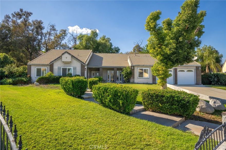 Welcome to 11292 Cadbury Drive, a spacious single-story retreat nestled in one of Riverside’s most desirable neighborhoods. This beautiful home features 5 bedrooms, 2.5 bathrooms, and approximately 2,810 square feet of living space, all situated on an expansive 24,394-square-foot lot that offers endless potential. From the moment you arrive, the charming brick-accented exterior, manicured landscaping, and inviting entryway set the tone for what awaits inside. Step through the double doors into a bright and airy living space highlighted by vaulted ceilings and natural light that fills every corner. The open floor plan flows seamlessly from the formal living and dining areas to the spacious kitchen, which features white cabinetry, granite countertops, and a center island with built-in wine storage—perfect for both everyday living and entertaining. Adjacent to the kitchen, the cozy family room with a fireplace creates a warm and comfortable atmosphere ideal for gatherings with loved ones. The primary suite serves as a peaceful retreat with its own fireplace, private patio access, and a large ensuite bathroom complete with dual sinks, a soaking tub, a separate shower, and a generous walk-in closet. The additional bedrooms are well-sized, offering versatility for guests, a home office, or a gym, while the bonus room provides even more flexibility for a game room, home studio, or lounge area. There house sits on a single level with an exception to the oversized loft that provides as a flex space. Step outside to your private backyard oasis with a wide concrete patio and lush green lawn framed by mature trees—perfect for entertaining, relaxing, or creating your dream outdoor space. The oversized lot offers plenty of room for a pool, garden, or future expansion. Additional highlights include an indoor laundry room with storage, a two-car garage, ample driveway parking, and a quiet cul-de-sac location that provides both privacy and convenience. Ideally situated near schools, parks, shopping, and freeway access, this home perfectly balances comfort, function, and opportunity. 11292 Cadbury Drive isn’t just a home—it’s a place to create lasting memories, enjoy peaceful living, and make your vision of homeownership a reality.