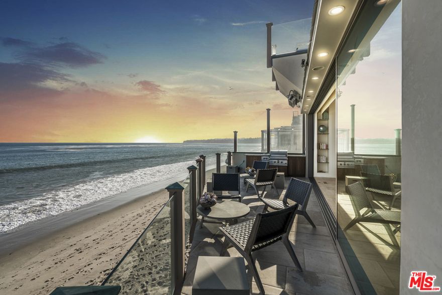 This magnificent architectural sitting on a dry, sandy beach offers panoramic ocean views spanning from the Queen's Necklace all the way to Point Dume. Catch a glimpse of a migrating whale or a dolphin through the clear glass railing, giving you the feeling of walking on water. Marvel in the Chef's kitchen with a warmth of teak cabinetry, built-in appliances, Viking range & stove, Subzero refrigerators & a Miele espresso maker to go with the picturesque Malibu sunrise. The oceanfront living room opens up to a generous terrace creating an unparalleled beachfront entertainment area. The ocean facing Master Suite is light & bright with breathtaking views, fireplace, his, her bathroom & two walk-in closets. Additionally, there's a large beach-level veranda perfect for outdoor entertaining. Other amenities include one-touch lighting, sound system, security cameras, built-in BBQ, maid's quarters, wine room, storage area, 2 car garage, hot tub & large bonus room (potentially a fourth bedroom)