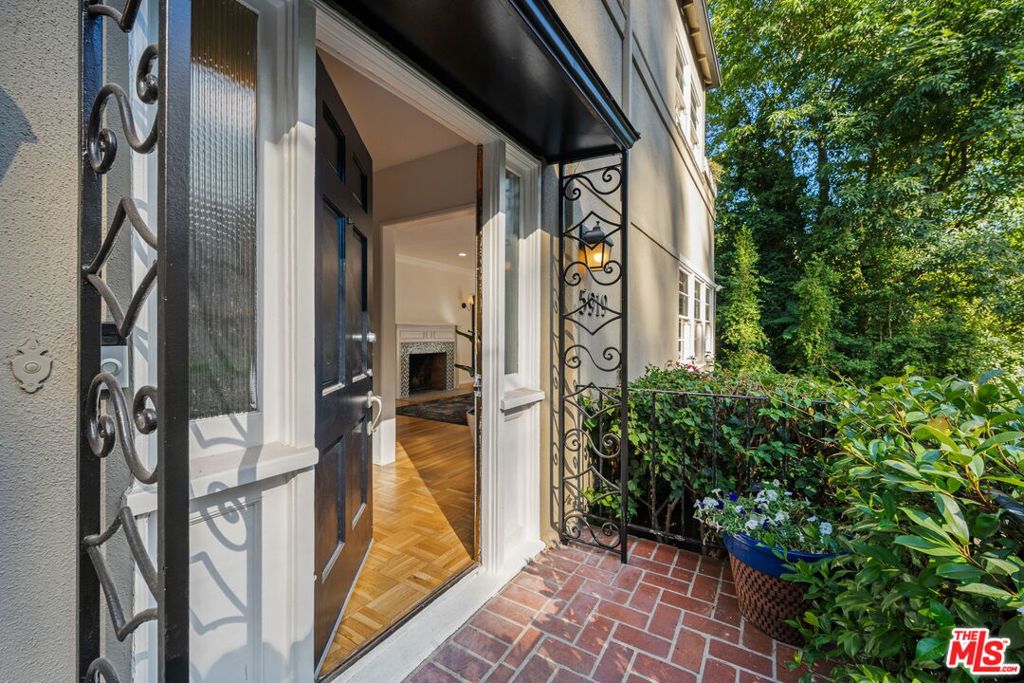 Step into timeless elegance with this enchanting prime Hollywood Hills residence where vintage charm meets modern comfort. Featuring two expansive primary suites and a generous den that easily doubles as a third bedroom, this home offers flexibility and space for a variety of lifestyles. From the moment you enter, a dramatic staircase sets the tone, leading you into gracious living and dining rooms adorned with original period details and warm, inviting ambiance. The chef-inspired kitchen boasts an updated stove and classic built-ins, blending functionality with character. Unwind in the entertainment room or office, complete with a cozy fireplace, that opens seamlessly onto a wraparound deck enveloped by lush greenery for ultimate privacy. Whether you're hosting friends under the stars or enjoying a quiet evening with a favorite novel, this home offers the perfect backdrop. Additional features include a two-car garage with ample storage, abundant natural light throughout, and the kind of timeless architectural character rarely found today. Nestled just below the iconic Hollyridge Trail, you'll enjoy a harmonious blend of nature and privacy in a truly legendary location.