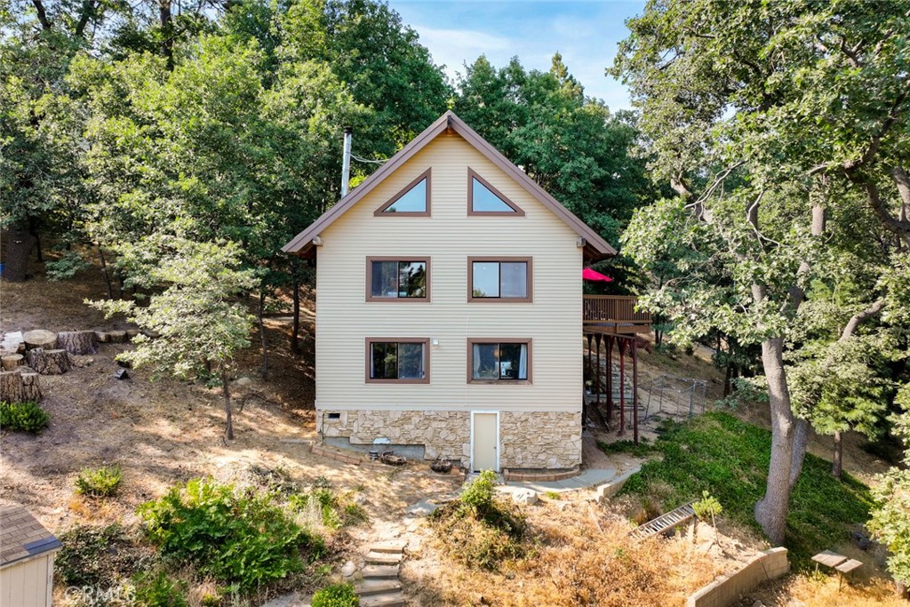 Welcome to 20 Oak Leaf Lane, nestled in the peaceful Smiley Park Country Club community—where nature, privacy, and mountain living come together. Whether you're searching for a full-time residence or a vacation escape, this beautifully located home offers the ideal mountain lifestyle.
Set on nearly an acre of land, this charming 3-bedroom, 2-bath home with an additional loft delivers incredible privacy, tranquil forest views, and space to spread out. Enjoy breathtaking sunsets and fresh pine-scented air from the oversized deck—perfect for relaxing, entertaining, or soaking in the quiet surroundings.
Step inside to a warm and inviting living area with soaring two-story ceilings, an open-concept floor plan, and a cozy wood-burning stove that brings character and comfort. The spacious kitchen is designed for cooking large meals and gathering with friends and family, whether it's a holiday weekend or a quiet weeknight.
The home offers two bedrooms on the main floor, a third bedroom upstairs along with a flexible loft space, and a large lower-level den currently being used as a fourth sleeping area or recreation space.
As part of Smiley Park Country Club, you’ll enjoy community amenities like a seasonal swimming pool, clubhouse (with a pool table), and year-round events—all without the hassle of maintenance. Located just a short drive up the hill from the Inland Empire, and within 30 minutes of Lake Arrowhead, Snow Valley, and Big Bear, this is mountain living at its best.
Whether you’re looking for a peaceful full-time home, a cozy vacation retreat, or a place to create lasting family memories, this is your chance to own a slice of the San Bernardino Mountains.