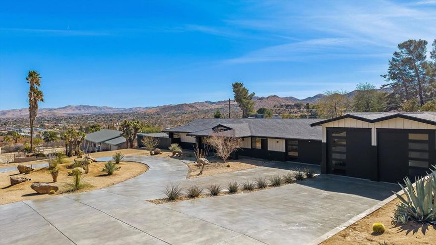 Showcasing gorgeous mountain views from this elevated location in the Country Club neighborhood of Yucca Valley. This property has so much to offer, including a DOUBLE RV garage (in addition to the extra deep 2-car garage), separate casita and a sleek, stylish design. Enjoy excellent curb appeal when arriving to the recently painted home via the circular drive. The kitchen is the heart of the open concept living area with stainless appliances, quartz counters, and plenty of storage. In the living room, enjoy a beautiful statement fireplace, flanked by oversized windows. A very large bonus room can be accessed off the living room and could be utilized in just about any capacity- artist studio, playroom for kids, large office space, music room... The amply-sized primary bedroom boasts its own spa-like bath with deep tub and double sinks. Two spacious guest rooms and two additional baths provide plenty of space for family or guests. Accessible from the very private backyard is a separate casita with powder room for even more flex space. Recent updates include landscape, roof, replacement of all windows and doors, casita flooring, updated fireplace facade and hearth, added rain gutters, septic, painted property inside and out, upgraded garage doors and epoxy flooring in garage.