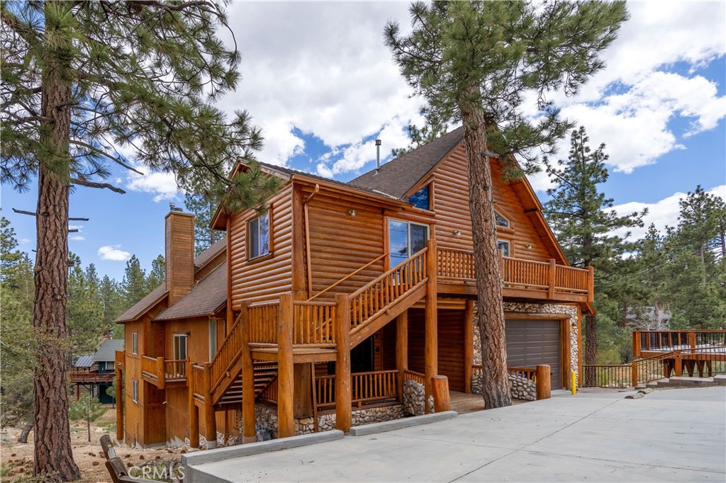 Escape to Five Bears Den, the ultimate mountain log cabin retreat in Big Bear! Amazing Value with this offering! This impressive 6-bedroom cabin spans 3326 square feet on a generous 7460 square foot lot, offering a perfect getaway for vacations, group gatherings, or corporate retreats. Added bonus, the neighboring lot is included in the sale for a future build or just additional yard space on a 10,000 sq ft lot! Spanning three levels, the cabin is designed for optimal privacy, with two bedrooms on each floor, ensuring a perfect balance between shared moments and personal space. The main family room features an amazing rock fireplace, a comfortable sofa, Smart TV, and access to the main bedroom, along with multiple adjacent balconies offering stunning 180-degree views. The upper level boasts a bar & wet bar, a large Smart TV and seating area, two bedrooms, and a full bathroom, each room thoughtfully curated to reflect the mountain setting. The main living level has plenty of room for large gatherings. The lower level is an oasis of fun, with a game room featuring full-sized arcade games, a wet bar and fridge, and even a popcorn machine. This floor also offers two bedrooms and a full bathroom. Outside, the spacious grounds provide ample space for walks and conversations, while the wraparound redwood decks offer the perfect setting for relaxation and family gatherings. Immerse yourself in the brand-new hot tub surrounded by boulders and enjoy the serene beauty of the surroundings.