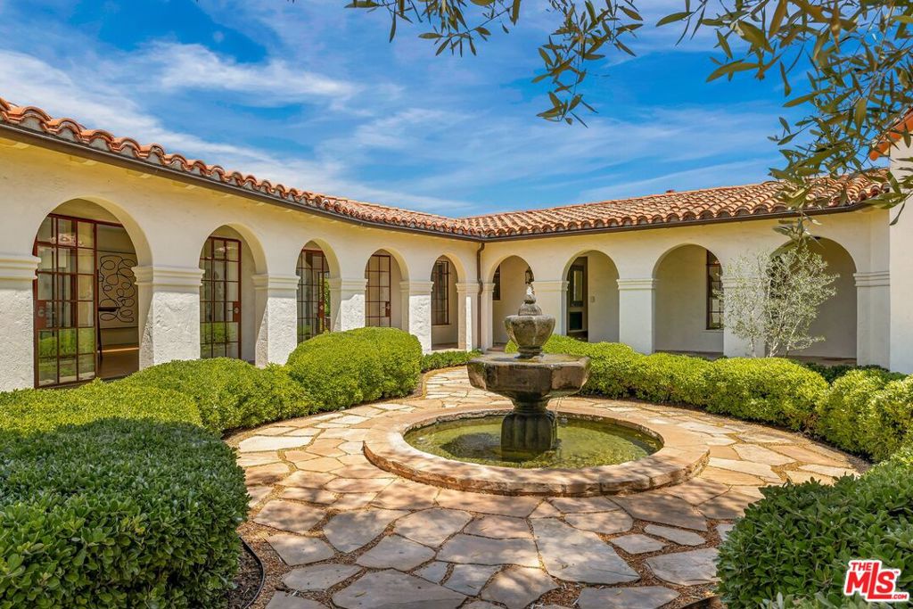 Exquisite1929 Montecito-style home on an expansive sun-drenched 32,423 sq. ft. lot in prime Brentwood. Gated, gravel driveway and courtyard with fountain leads to a charming and private celebrity compound. Original Saltillo tile entry and stunning sunken living room with beamed ceiling, wood-burning fireplace and large picture window overlooking the pool and grounds. Charming family room with flagstone pavers, built-ins, a wood-burning fireplace and separate office. Wonderful dining room that opens onto a relaxing sunroom and outdoor patio with cozy wood-burning fireplace. Open and bright skylight-filled kitchen/great-room with french doors opening to the adjacent count yard is perfect for large scale gatherings. Romantic primary suite with another fireplace, private terrace/garden and outdoor spa. Two additional en-suite bedrooms plus an inviting one-bedroom guest house. Carport with beamed ceiling and french doors. The home has several patios/terraces to relax, entertain or dine alfresco while offering tree-top and serene canyon views. A very special and magical property.