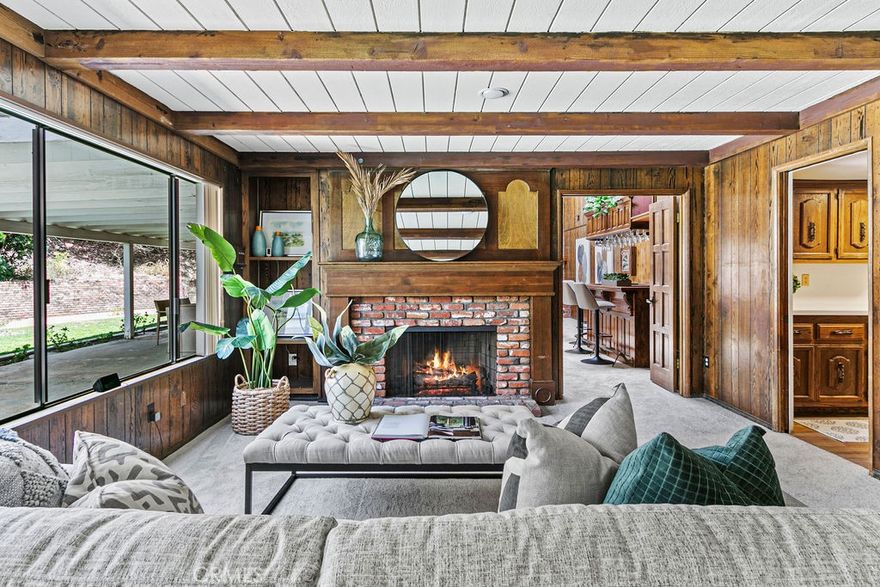 Situated in the coveted rolling hills of Villa Park, this commanding estate sits at an elevated position to the street and exudes the timeless elegance of a time past. In the same family for nearly 4 decades, this timeless traditional styled home is ready for the next buyer to bring it back to its former glory. Perched atop an elevated lot, this home screams potential for a truly impressive elevation and curb appeal. This 5 bed, 4 bath estate boasts nearly 4000 square feet of living space, a spacious traditional floorplan, and large entertaining styled backyard. Enter through lead glass inlaid front doors w/ elegant sidelights into a spacious entry and show style living room. Living room is huge with large windows letting in tons of light. Living room is open concept with the dining room giving a large spacious feel and easy entertainment space for those cherished holidays. Kitchen is dated but locationally perfect, with easy access for dining room serving, rear located for easy vision to the backyard and sprawling pool, and direct proximity to the family room. This kitchen is the central hub of the downstairs floorplan. The family room is rear floorplan located and has easy access to the entertaining styled backyard. Huge window walls give full line of site to the entire yard. Framed with an antique brick fireplace, wood paneled walls, exposed wood beams, and natural wood styled mantle, this room exudes the rich and elegant finishes of the period it was built. HUGE bonus room feels so nostalgic. Floor to ceiling brick finished fireplace wall, w/ wood stacking cove, built in bar, wood paneling, window wall, and billiards table reminds one of the fun this room would have been. This floorplan has a DOWNSTAIRS BEDROOM with easy downstairs bath access. Spacious laundry and three car garage are also big benefits. Upstairs one finds the primary bedroom and bath. The primary is sprawling, with corner windows that allow plenty of light to flood in. Primary bath is spacious with room to renovate. Secondary bedrooms are spacious, and hall bath is also ready for a facelift. Space for dual vanity sinks, tub and shower, and water closet make this a larger than normal space with plenty of potential. Backyard instantly reminds us of a simpler time, with HUGE covered patio for those lazy summer days.   There is plenty of grass for room to run, large pool and elevated spa, lush but overgrown mature landscape, fire pit, gazebo, dog run, and swing set. Call for more details!