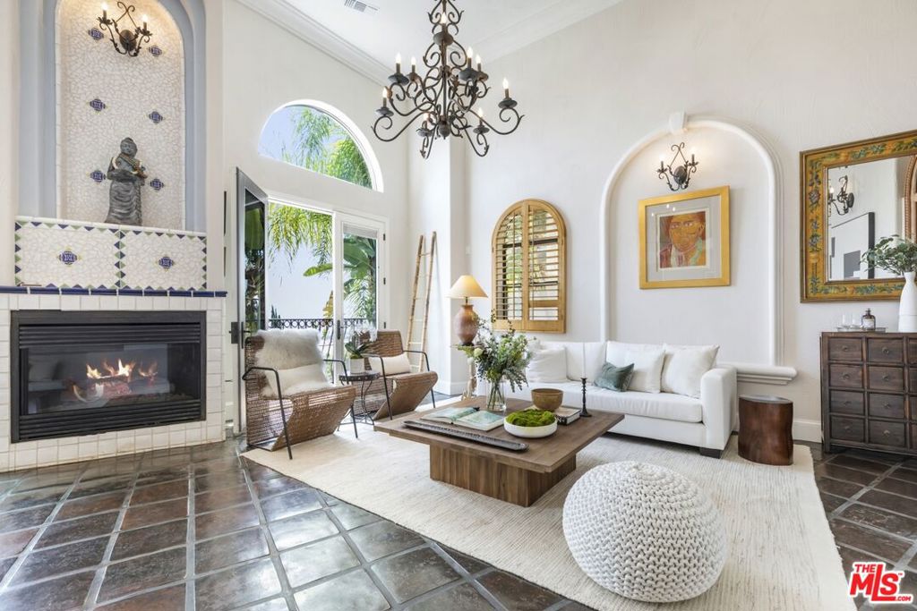 Tenant-occupied. The property is currently leased, and the new owner would assume the existing lease. Perched atop the hills of the Hollywood Dell, stands this custom-built Mediterranean home. Enjoy expansive city and ocean views from the open concept living room with 20-foot ceilings characterized by wrought iron chandeliers and a built-in wet bar. A formal dining area connects the great room to a gourmet kitchen complete with Thermador range, Subzero refrigerator, Bosch dishwasher, a copper sink and ample built-in storage. Upstairs, find a flexible mezzanine level with 3/4 bath, which serves as the perfect setting for a den, office or library. On the top level are two guest bedrooms with full bathrooms, and a hotel-like primary suite with fireplace and private balcony with breathtaking views. Host dinner parties on the rooftop garden, adorned with fragrant roses and citrus vines. Other features include: French oak hardwood floors, elevator, 3-car garage and Pella doors and windows.