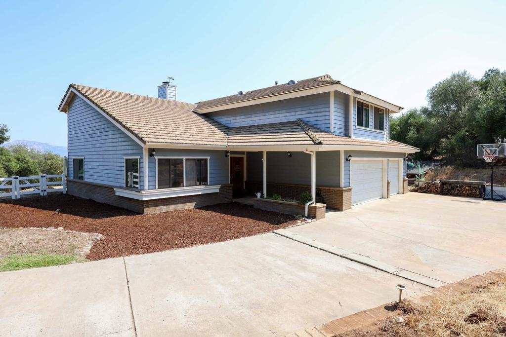 Surrounded by majestic oak trees on a quiet cul-de-sac, this charming Alpine home offers country living at its finest. The expansive interior features vaulted wood ceilings, new LVP flooring throughout, re-modeled bathrooms and formal dining and living spaces. The bright eat-in kitchen includes updated cabinetry and a breakfast bar, which opens onto a cozy family room with a beautiful gas fireplace. Four spacious bedrooms are on the second story, including a sizable primary suite with its own double-sided fireplace and a private balcony that offers sweeping mountain views. This home is situated on over an acre, and includes a solar-heated pool, multiple seating and dining areas, a bike ramp and a custom play area built under an oak tree. The relatively flat lot offers countless opportunities to expand or add an ADU, while still having plenty of space for RVs/trailers and other outdoor toys.