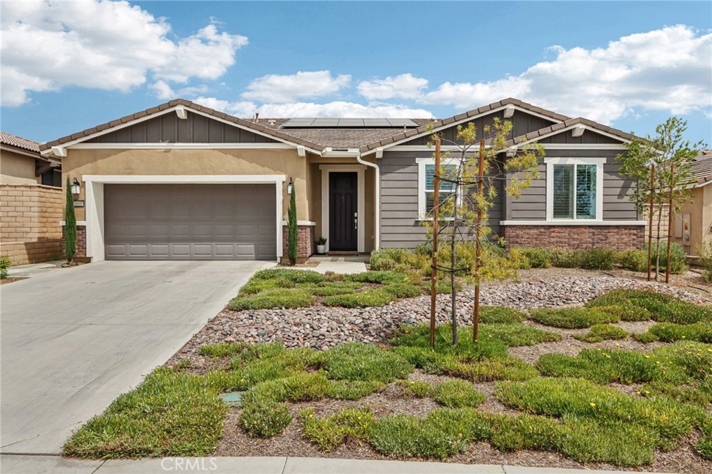 Gorgeous Home with Paid Solar & Stylish Upgrades. This stunning home impresses from the start with paid solar, attractive curb appeal, and low-maintenance artificial turf in the backyard. Inside, enjoy durable luxury vinyl plank flooring throughout, wood shutters, and a bright open great room that seamlessly blends the kitchen, living, and dining areas—perfect for everyday living and entertaining. The upgraded kitchen features smoke-colored cabinetry, double ovens, a farm sink, huge island with bar seating, stainless steel appliances, and a walk-in pantry. A slider opens to the backyard patio with vinyl fencing and peekaboo mountain views. The spacious primary suite is privately situated and offers a dual sink vanity, soaking tub, separate shower, and a large walk-in closet. Two well-sized bedrooms and a full bathroom with dual vanities are located off the main hallway. Additional highlights include a den/office off the entry, a laundry room with ample storage, a tandem 3-car garage with direct access, epoxy floors, port for electric car charger, and tankless water heater. Located in a desirable neighborhood close to schools, shopping, and the 215 freeway, this home blends modern comfort with timeless style.