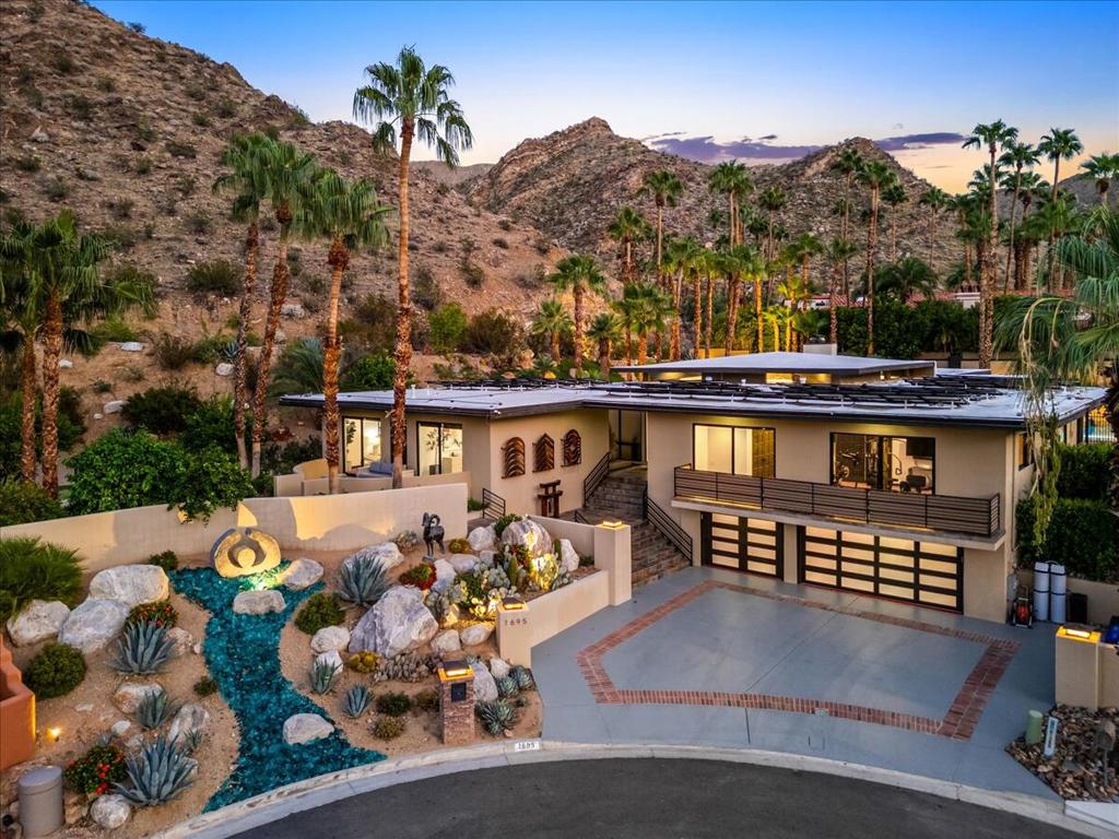 An architectural statement in the coveted Andreas Hills of South Palm Springs, this 6,252 sq. ft. custom contemporary showcases bold design, privacy, and effortless desert living. Perched on a quiet cul-de-sac on fee land (you own it!), the home captures dramatic mountain views and a seamless connection between indoor and outdoor spaces.Expansive walls of glass draw the eye to the resort-style backyard complete with a newly resurfaced pool and spa, rock wall water feature, and mini-golf area that brings playfulness to the sophisticated design. Enjoy gatherings under the covered lounge with misting system, knowing the home is powered by paid solar and supported by a natural gas backup generator for comfort and efficiency.Inside, soaring ceilings and open living areas create volume and flow, while the chef's kitchen impresses with a massive island, generous counter space, and effortless connection to the great room. The home offers 5 bedrooms, 4 full baths plus a powder room, and a 3-car garage, balancing luxury with everyday practicality.Additional features include a media room wired for projection and surround sound, a dedicated gym, and freshly painted interiors ready for your personal touch. A recent pre-listing inspection with repairs completed ensures peace of mind and immediate enjoyment.This is a rare opportunity to own a modern architectural retreat in one of South Palm Springs' most sought-after neighborhoods where style, serenity, and sophistication come together under one roof.