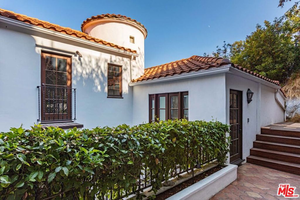 Perched above the iconic Sunset Strip, this chic and charming Hollywood retreat is the ultimate entertainer's paradise. Once owned by a celebrity, the home has been tastefully remodeled with timeless elegance and sophistication. Nestled in the hills with some city light views, it features warm-toned hardwood floors, soaring ceilings, sun-drenched rooms, and stunning old-Hollywood design touches. Step into a dramatic formal living room with beamed ceilings and a statement fireplace. The chef's kitchen dazzles with marble countertops and flows into a stylish formal dining room beneath a striking glass ceiling. A cozy den/office sits just off the kitchen, perfect for working from home or relaxing in style. The glamorous primary suite offers high ceilings, a walk-in closet, and a luxe, newly renovated bathroom. Upstairs, you'll find two spacious bedrooms with a beautifully updated shared bath. A fourth bedroom on the lower level features its own private entrance and en-suite bathroom ideal for guests or live-in staff. Designed for effortless entertaining, the home includes a game room, a large media room, and an expansive backyard oasis with a sparkling pool, hot tub, fire pit, cabanas, and built-in BBQ. Multiple patios provide secluded spots to unwind, all just moments from the heart of Sunset Blvd.'s best outdoor dining and shopping. Lease offered unfurnished.