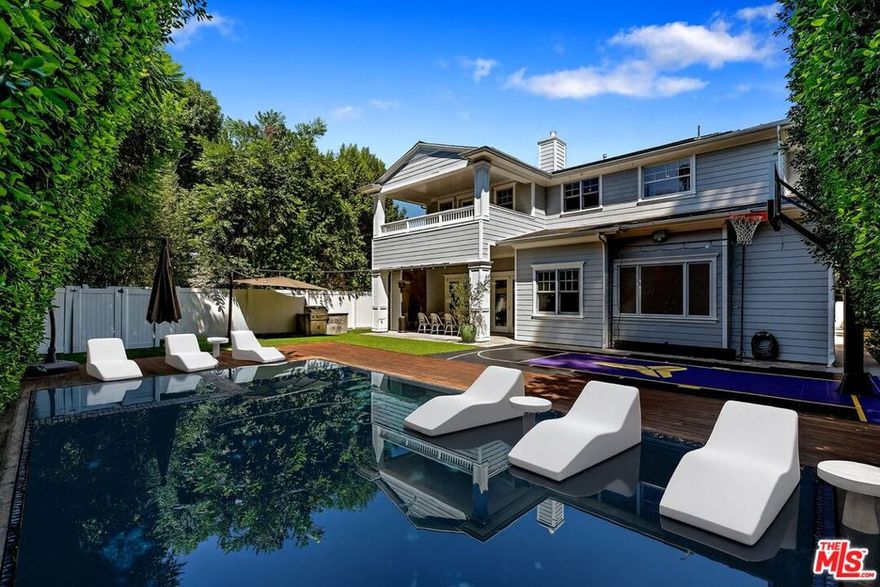 Modern Cape Cod masterpiece blending luxury and comfort with exquisite detailing. This 5 bed/6 bath home plus office/studio boasts soaring 11-ft ceilings, a grand living room, formal dining with wine room, and a chef's kitchen with Calcutta marble island, top appliances, and reverse osmosis system. Walls of glass open to a private entertainer's yard with zero-edge saltwater pool/spa and IPE deck. The primary suite offers a fireplace, balcony, sitting area, walk-in closet, office, and spa-like marble bath. Highlights include oak floors, wainscoting, Control4 smart home, hardwired alarm, cameras, shatter proof film on glass windows and doors, double gated entry, and solar for home & pool. Freshly painted with new fixtures, custom wallpaper, and more, move-in ready. Fruit and rose gardens complete this oasis, just steps from Ventura Blvd's best dining and shops.  ***Walking distance to Dixie Canyon Community Charter School. (virtually staged.)