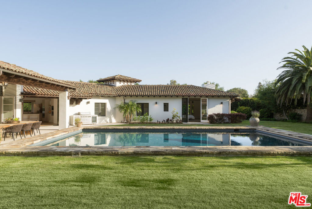 Elegant, high-level design meets Hacienda style living in this newly renovated and expanded, one-story Spanish masterpiece in the heart of Montecito's Golden Quadrangle. Privately set behind double gates, an olive tree-lined entryway and long gravel driveway lead you to over an acre of lush grounds and your Mediterranean retreat. Step into a completely reimagined villa, where the preservation of traditional elements, and enhancement of key features through natural materials, an earthy palette, and intricate detailing, provide a beautifully decorated yet functional residence. Enter the sun-drenched foyer, to open living spaces with clean lines and modern aesthetics. The living room reveals high ceilings with wood beams and an adjacent, dark lime-washed bar nook. Curved archways lead you to your dining area and expansive chef's kitchen, with top-of-the-line appliances. A private and luxurious primary suite awaits at the end of the South wing of the estate. The guest bedrooms, all with ensuite bathrooms, line the brightly lit, glass enclosed gallery across the courtyard. In total, five bedrooms and five and half bathrooms make up the main home. In addition, a one-bedroom, one-bath full-size ADU with a kitchen and living room, serves as guest quarters or multi-use family living. All rooms access the outdoor entertaining spaces and the massive resort-style pool poses as the centerpiece of the yard. An al fresco dining pavilion and cabana, both with cozy fireplaces, provide the perfect setting for memorable gatherings large and small with a backdrop of the majestic Santa Ynez mountains. The property features several exotic fruit trees, and plenty of room to create additional living or recreational spaces. A rare opportunity to acquire a meticulously crafted, indoor-outdoor estate, on one of the most coveted streets in the esteemed Montecito Union School District. Enjoy nearby landmarks including the San Ysidro Ranch, Hot Springs hiking trails, and the dining and shopping of the upper and lower villages. A true gem in the epicenter of Montecito.