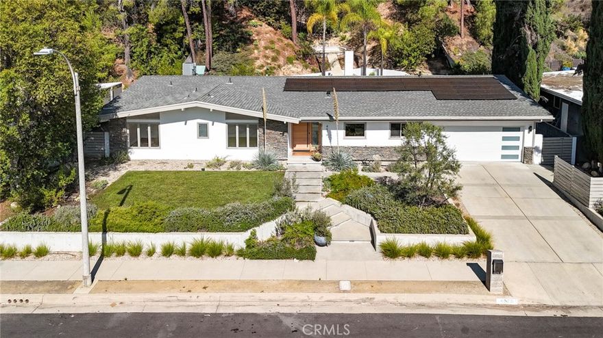 Newly remodeled mid-century modern stunner designed by a renowned architect, nestled on tree-lined street south of the boulevard. Set on nearly 15,000 sq ft of meticulously landscaped grounds, this 4-bedroom, 3.5-bathroom home spans 2,864 sq ft of light-filled living space. Clean modern lines and lush, drought-tolerant gardens frame the exterior, creating a peaceful, private retreat. A custom wood front door opens into a bright, expansive living area with new floors, exposed wood-beam ceilings, and striking double-sided fieldstone fireplace. Walls of glass line the back of the home, opening to a resort-style backyard complete with heated pool, hot tub, outdoor fireplace, view terrace, and playset—ideal for year-round entertaining and family enjoyment. At the heart of the home is the remodeled gourmet kitchen featuring an eat-in island, breakfast bar, custom white oak cabinetry, and stainless steel appliances—perfect for both casual meals and entertaining. The luxurious primary suite is a true sanctuary, boasting spa-like bath with dual vanities and spacious walk-in closet. Additional highlights include owned solar panels, and eco-conscious landscaping for effortless, sustainable living. Don’t miss your chance to call this architectural gem home!