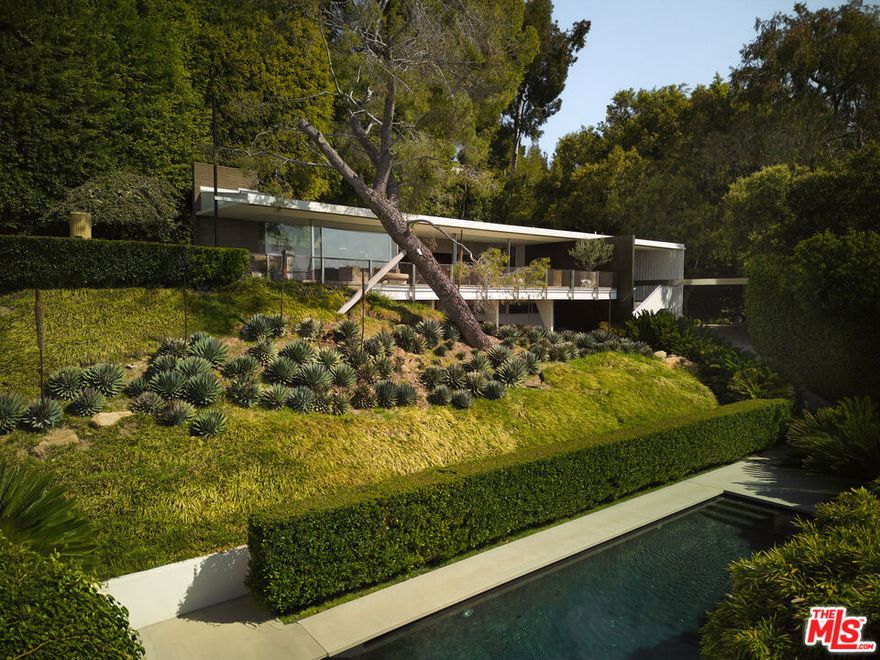 The Brown House, originally crafted in 1955 by the renowned Richard Neutra, stands as a quintessential architectural masterpiece nestled in the prestigious enclave of Bel Air. One of the most iconic homes to be built, it has undergone a meticulous restoration, thoughtfully revering Neutra's pioneering vision while integrating modern luxuries. A true encapsulation of living in a work of art. The property boasts commanding 180-degree views of Los Angeles, restored original cabinetry, and terrazzo flooring, all encapsulated by sweeping walls of glass that blend seamlessly with its serene Romanesque gardens. Expertly revived by leading fashion designers and visionaries, the home features refined aesthetics, including a palatial double-wide living room and exquisite lacquered walls in the primary suite. Comprising up to six elegant bedrooms, two state-of-the-art kitchens, and sumptuous bathrooms, the residence epitomizes culinary and architectural excellence. This is a rare opportunity to acquire a piece of architectural heritage, offering a lifestyle marked by grandeur and exclusivity in one of the most coveted locations.