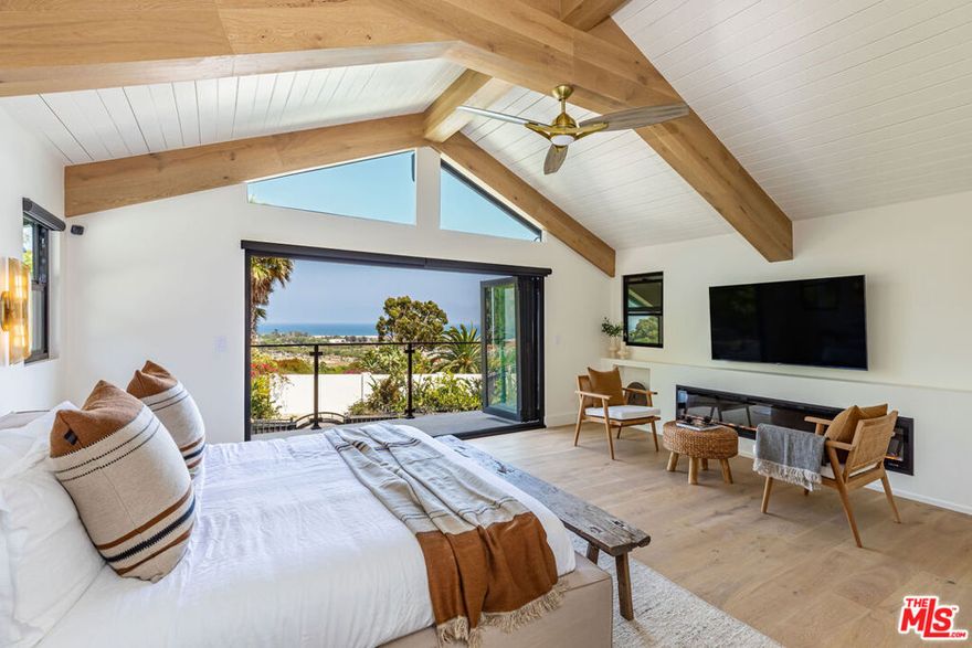 Experience modern coastal living in this inviting tri-level home, positioned in the desirable Malibu Knolls neighborhood near Pepperdine University. This 3-bedroom, 4-bathroom residence captures sweeping views of the Pacific and offers a bright, open interior designed for both comfort and style. The beautifully updated kitchen boasts premium appliances, a six-burner range, double ovens, and a large island with built-in charging station, while the adjacent dining area with mini bar offers the perfect space for gathering. The spacious living room is enhanced by lofty ceilings and a striking fireplace. Each level includes its own bedroom and bath, providing exceptional privacy, with the primary suite boasting panoramic ocean views and a spa-like bathroom retreat. Additional highlights include a dedicated laundry/mud room, a two-car garage, solar panels, and various tech upgrades. Outdoors, enjoy a large flat yard, patio with a state-of-the-art outdoor kitchen, expansive deck, and private sauna - an ideal setting for entertaining or relaxing in the coastal breeze. Just minutes from Cross Creek and the Country Mart for convenient access to Malibu's premier dining and shopping.