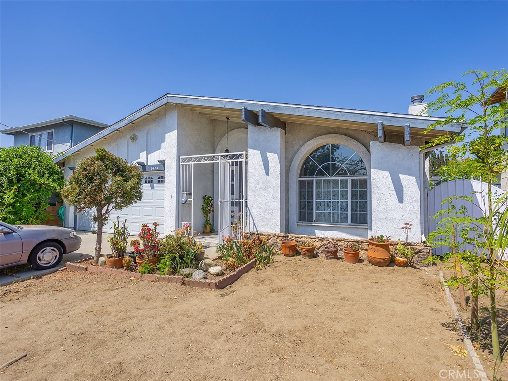 Welcome to this charming mini gated estate nestled on a spacious 7,500 square foot lot, offering both privacy and comfort in a beautifully maintained setting. This inviting home spans 1,979 square feet and features three generously sized bedrooms and two well-appointed bathrooms. Step inside to a grand formal tile entryway that sets the tone for the rest of the residence. The living room boasts a cozy fireplace and soaring vaulted ceiling, creating a warm and open ambiance that flows seamlessly into the adjacent dining room, also graced with vaulted ceilings. The remodeled kitchen offers both style and functionality, complete with a dining area ideal for casual meals and entertaining. The comfortable primary suite provides a relaxing retreat with thoughtful updates and ample space. Enjoy indoor-outdoor living with an enclosed patio as well as a covered patio that opens to an impressive backyard oasis filled with a variety of vegetables and room to garden or entertain. Additional highlights include a two-car attached garage and the convenience of central heating and air. This well-rounded property combines thoughtful design, modern upgrades, and a welcoming outdoor space, making it a true gem for anyone seeking comfort and character.
