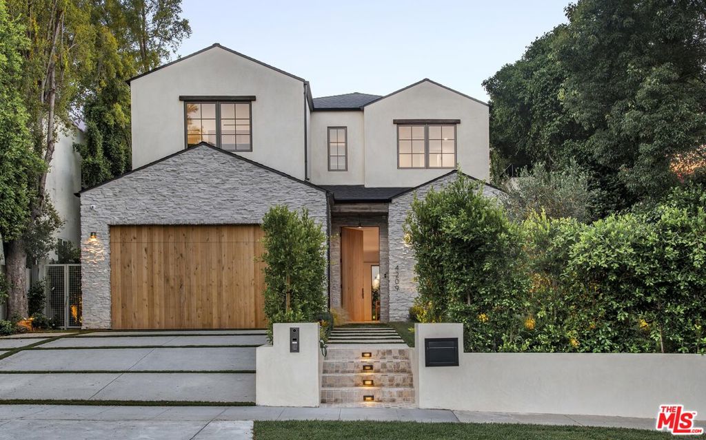 Introducing a picture-perfect new construction nestled in the highly sought-after Footbridge Square enclave of Studio City. This exquisite two-story residence boasts 5 bedrooms and 5.5 bathrooms and includes a fully permitted detached Accessory Dwelling Unit (ADU), seamlessly blending refined design with effortless California living. Bathed in natural light and thoughtfully crafted for open-concept living, the home offers graceful transitions between indoor and outdoor spaces. Upon entry, warm hardwood floors and a serene palette set a sophisticated tone. A welcoming living area features a sleek modern fireplace, while a powder room off the entry stuns with lime washed walls and a vintage-sourced sink. The breathtaking kitchen is a true showpiece, outfitted with Miele appliances, marble countertops with an integrated marble sink, custom oak cabinetry, and a richly appointed butler's pantry that flows into the dining area for effortless entertaining. The family room, adorned with custom oak built-ins, opens directly to the kitchen, creating a cohesive and inviting space ideal for gatherings. A guest suite or office, complete with generous storage, is tucked away on the main level for added versatility. Upstairs, three additional bedrooms include the remarkable primary suite, a true retreat featuring a custom-designed white oak walk-in closet, a marble fireplace, and a tranquil balcony overlooking the backyard. The spa-inspired primary bath showcases an expansive dual vanity, smart toilet, walk-in shower, and a soaking tub set against peaceful treetop views. Each bedroom includes an en suite bath, each uniquely designed with curated marble, oak millwork, and designer lighting. The upstairs laundry room is both functional and beautiful, with limestone floors, a vintage vessel sink, and a custom drying rack. Outdoors, a private sanctuary awaits with a sparkling pool and spa, a reclaimed oak pergola, and a built-in barbecue, perfect for al fresco dining. The fully integrated ADU (4211 Vantage Ave) offers its own elegance, featuring stained oak cabinetry, Caesarstone countertops with a concealed cooktop, Fisher & Paykel appliances, and a luxurious Cle-tiled bath with a vintage sink and spa shower. Additional amenities include a Control4 smart home system, built-in speakers throughout and security cameras. Located just moments from the Sportsmen's Lodge, Studio City Farmers Market, and Ventura Boulevard's premier shopping and dining, this extraordinary home strikes the perfect balance between modern sophistication and timeless charm.