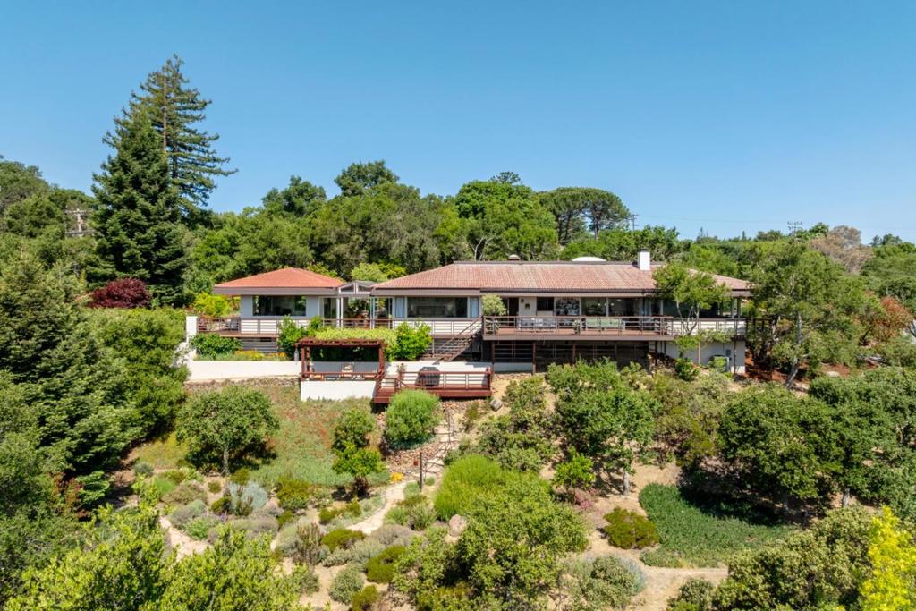 Welcome to this stunning home in Portola Valley, offering a perfect blend of comfort and elegance. With a generous living space of 4,088 sq ft situated on a 47,517 sq ft lot, this property provides ample room for relaxation and entertainment. The home features three spacious bedrooms, including a primary bedroom conveniently located on the ground floor, and two full bathrooms equipped with double sinks. Separate structure perfect for office or large gym. Sunroom for relaxing and views. PV Schools The kitchen is a culinary delight with its sleek granite countertops, ideal for preparing gourmet meals. Enjoy dining in the formal dining room or the eat-in kitchen, catering to both casual and formal occasions. The family room offers a separate retreat for gatherings and relaxation. This beautiful residence boasts exquisite hardwood and wood flooring throughout, adding warmth and charm to the interior. Cozy up by the fireplace on cooler evenings, creating a perfect ambiance. Laundry is convenient with an inside washer and dryer setup. The home is part of the Portola Valley Elementary School District. Additional amenities include central AC, a whole house/attic fan, central forced air heating, and a two-car garage, ensuring comfort and practicality all year round.