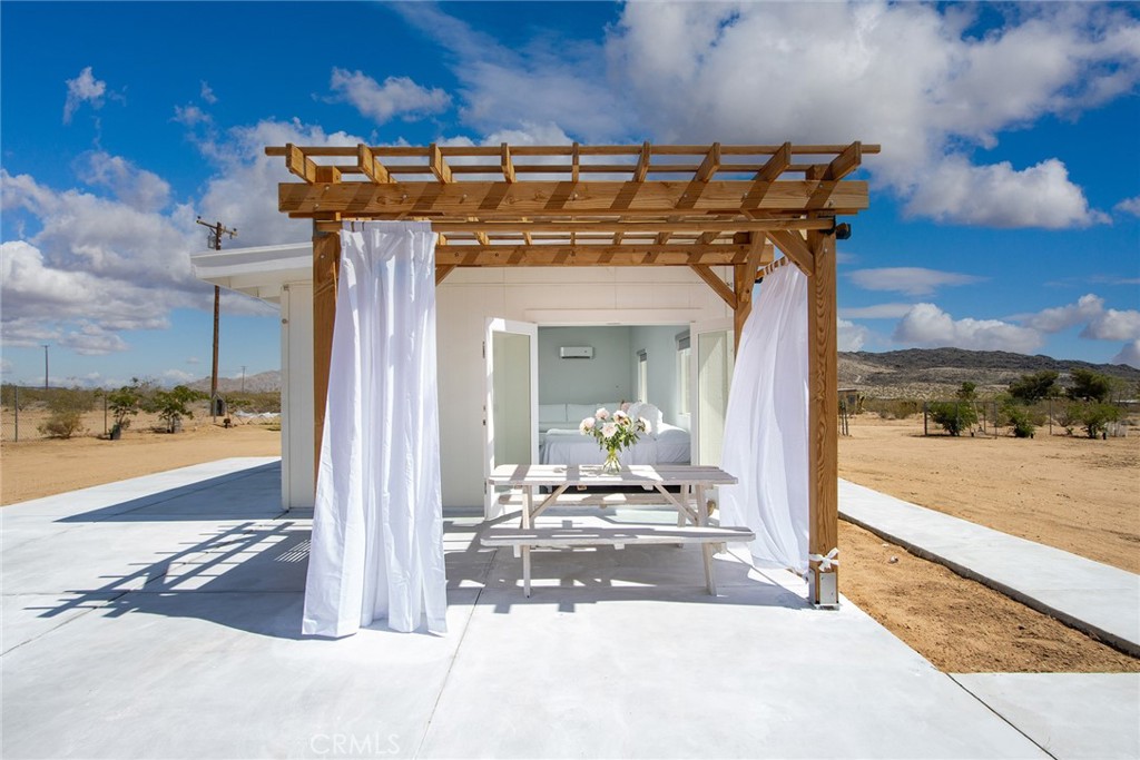Landers Nexus Homesteader: Beautifully reimagined homesteader cabin – converted from Rec Cabin to SFR, allowing for vacation rental permits and conventional financing. Located at the nexus of Landers, with both the world’s largest freestanding boulder - Giant Rock - and The Integratron only minutes away. A short distance farther, La Copine gourmet restaurant serves up nationally acclaimed cuisine. Sit on the porch sipping coffee, while gazing at iconic Goat Mountain to the east – hike to the top from home after breakfast! Visit Gubler Orchard Nursery nearby, one of the highest-rated growers of orchids. Hang with your furry friends in the FULLY-FENCED yard. Relax in the splendor of this cozily appointed cabin, or sleep outside under the permitted pergola recently built on the concrete porch. Fresh drywall, paint, electric wiring and fixtures, as well as a 200 Amp electric panel. Custom roller window coverings, stackable washer & dryer, retro refrigerator and ductless mini- split AC/Heating. Bathroom fully updated with a modern touch including a walk-in shower, floating sink, over-sized medicine cabinet for storage, closet nook and low flow toilet. Stylized, high-quality modern remodel. Perfect in every way!