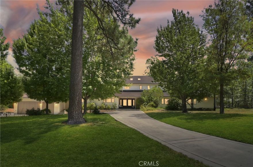 Over an ACRE, behind privacy gates, the utmost in privacy, yet, just a short stroll to the private Tavern Bay Beach Club. This Lake Arrowhead estate, with Lake Rights, unfolds like a love letter to mountain living. Lushly landscaped, forested, & level grounds, this home is not just a residence but a sanctuary—where nature, romance, & luxury harmonize. From the moment you arrive, the automated entry gate opens to reveal sprawling lawns adorned with flowers and the whimsical beauty of the “Three Sisters” sequoias —kissed by alpine breezes. Outdoors, every gathering becomes a memory. The bocce ball & expansive sport court invite laughter and competition—transforming easily into a dance floor under the stars. The custom bar and grill beckon for twilight feasts, while the above-ground spa bubbles beside twinkling landscape lighting, wrapping evenings in romance. Whether entertaining dozens or enjoying quiet solitude, this property is designed for joy. Inside, craftsmanship meets warmth. Stone and wood floors, wainscoting, cove moldings, and solid wood interior doors create a home rich with character. The oversized living room fireplace glows with welcoming grandeur, while the chef’s kitchen is a culinary dream: six-burner gas cooktop, convection double ovens, walk-in pantry with wine cooler & 2nd beverage fridge, & a commercial-grade stainless refrigerator & freezer. Every meal here feels celebratory. The primary suite, on the main level with 2nd fireplace and direct access to the back yard & spa, is a true retreat, offering a luxurious “Mr. Steam” shower that turns each morning into a spa ritual. With five bedrooms & five baths, + separate family room, each space balances privacy with connection, perfect for hosting loved ones in comfort. Thoughtful upgrades ensure ease and peace of mind—two air conditioners, four heater units with Nest controls, a whole-house generator, a private well with 5-stage filtration & 2,500-gallon storage tank, plus phone-app-enabled gates & heated three-car garage. Even parking welcomes guests graciously, with space for 12+ cars incl. a 40+ foot RV area with 50-amp hookup. Romantic, rare, & timeless, this estate is more than a home—it is a stage for life’s sweetest moments. Whether walking to the shores of Tavern Bay, sipping wine beneath your cherry tree in bloom, or dancing barefoot on the sports court by moonlight, you’ll find that this property was created for memories that last forever.   Could come mostly furnished.
