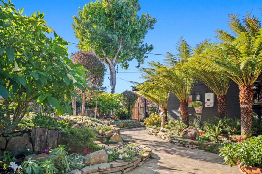 Uniquely Zen, one of a kind treasured property, home and guest house were lifted off the pages of a storybook and placed here at 1497 Highland Place. A custom designed gate and fence welcomes your arrival. Beyond the winding stone path sits this charming 1268 sq ft home surrounded by a beautiful professionally designed sanctuary garden. A whimsical home with color, arches, wood beam ceilings, stained glass, a Dutch door and multiple French Doors. This enclosed property invites serenity with a hot tub, an outdoor shower, water features and a fire pit. A spacious living room with a fireplace opens to the family room/dining room with garden views. An open kitchen with a wood burning stove and green tile counters.The laundry room off of the kitchen and has a sweet stained glass dutch door. A primary bedroom with a sitting room allows for plenty of natural light with three French doors and a wood burning stove, too. The blue tile hall bathroom displays a beautiful stained glass window. The Guest House features French doors and an open beam wood ceiling. Located on a quiet cul-de-sac Street within the upper Seaside sunbelt neighborhood. Enjoy easy access to General Jim Moore, Golfing, Ryan Ranch, Stone Creek Shopping Center, Restaurants, Highways and all the Monterey Peninsula offers.