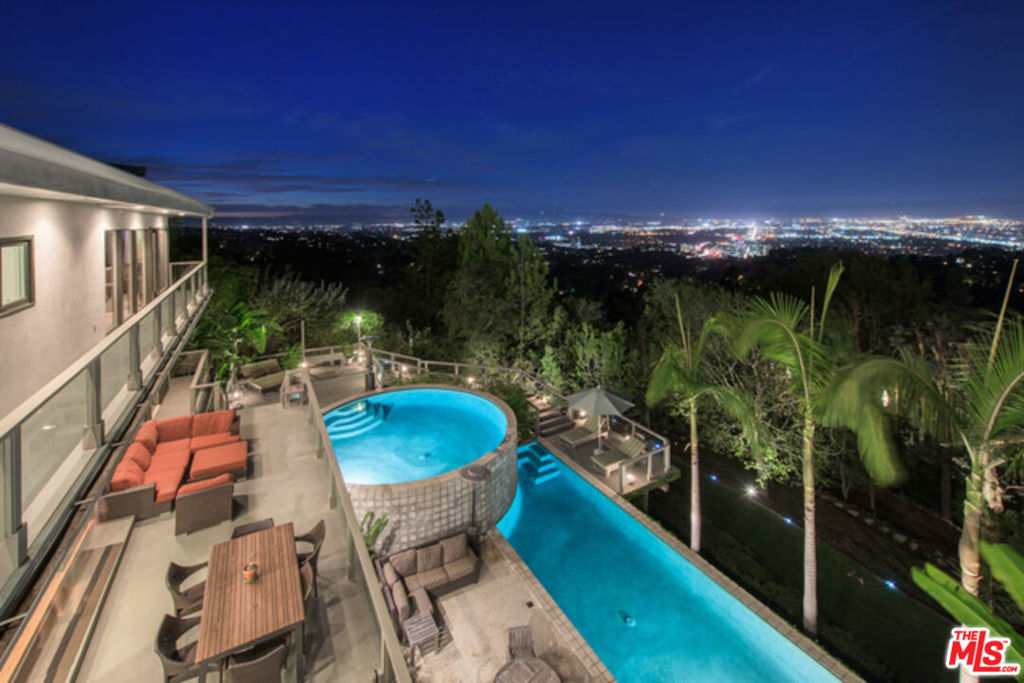 Mulholland Corridor Architectural Masterpiece! Bel-Air's Premier Private Sanctuary with Panoramic City Light Views! Indulge in timeless sophistication and cutting-edge design in this exclusive gated enclave along prestigious Mulholland Drive. This sensational 6-bedroom, 5.5-bath residence offers over-the-top luxury, dramatic architecture, and breathtaking city views from virtually every angle. Property Highlights: - Dual Primary Suites for ultimate privacy and flexibility- Chef's Kitchen with top-tier appliances and sleek finishes- Zen-Inspired Indoor-Outdoor Flow, bathed in natural light- Two Cascading Pools with serene lounging decks pure chill vibes- Dedicated Gym & Wellness Area to elevate your lifestyle- Multiple Entertaining Decks perfect for hosting under the stars. Lush gardens and Vegetable beds nestled among mature trees for tranquil seclusion. Whether you are an entertainer, industry elite, or seeking multigenerational comfort, this home provides an expansive canvas to live your dream. Modern elegance meets tranquil retreat-your hip , sexy sanctuary awaits!
