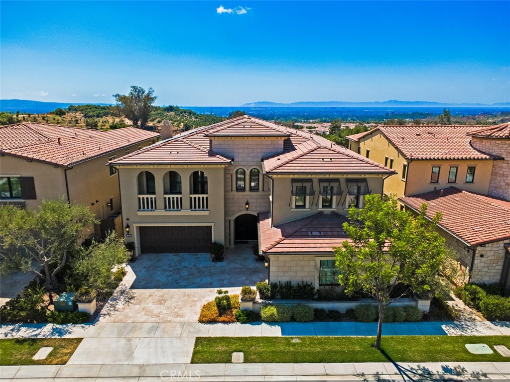 On one of the most sought-after streets in Orchard Hills’ Bella Vista enclave, 224 Clear Falls rises with distinction, offering a vantage few homes in the community can claim, rare views of the ocean, Catalina, and surrounding hills. Framed by the guard-gated serenity of Orchard Hills Estates and surrounded by lush avocado groves, this residence is a masterful balance of elegance, comfort, and enduring quality. Inside, a soaring two-story foyer and sweeping staircase create an unforgettable first impression, leading to a great room designed for both grand entertaining and everyday living. Glass doors open to an expansive covered outdoor lounge, where the extraordinary views become a natural extension of the home. The gourmet kitchen dazzles with its center island and wrap-around breakfast bar, bright dining nook, walk-in pantry, and the coveted secondary kitchen that makes hosting effortless. The primary suite is a sanctuary of its own, boasting a private view deck, dual walk-in closets, and a spa-inspired bath with Roman tub and luxe shower. Complementing the primary suite are four secondary bedrooms, each with ensuite baths, including one conveniently located on the main level for guests or multi-generational living. A spacious bonus room connects to a covered deck, while a refined home office and welcoming drop zone add versatility to the thoughtful floor plan. Meticulously maintained and enhanced with a rare four-car garage, this home is a jewel within one of Irvine’s most prestigious guard-gated communities. Just minutes from Irvine Spectrum, Tustin Marketplace, and major freeways, 224 Clear Falls embodies a lifestyle defined by prestige, serenity, and views unlike any other in Orchard Hills.