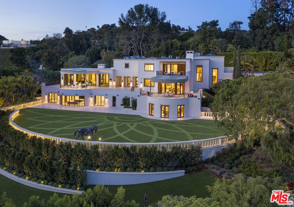 On a private road off lower Benedict, this exquisite 2.7-acre estate in the City of Beverly Hills stands as a testament to uncompromising luxury and refined taste. Architecture by the renowned William Hablinski, landscape artistry by Robert Truskowski and interiors by the celebrated Roger Thomas. The property's grandeur begins through an elegant gate with a park-like drive leading to the main residence. Upon entry, guests are welcomed into a sophisticated reception area with stylish arrival lounge and bar. The estate unfolds to reveal a grand living room with city light views, an expansive indoor/outdoor main dining area, the owner's office, a full Bel-Air Circuit capable digital Cinema, a spa suite, and large gymnasium. An elevator ensures effortless navigation throughout the residence. The owner's suite has dual amenities. Four en-suite guest bedrooms and a guest lanai suite with a full kitchen and living room provide ample space for visitors. The estate also includes three staff bedrooms with a dedicated kitchen and two security team bedrooms with a kitchenette. Outdoor amenities are equally impressive, featuring a professional tennis court with an air-conditioned seating house and kitchenette, an air-conditioned pool lanai house with kitchen, and meticulously landscaped grounds. This Beverly Hills masterpiece offers a perfect blend of privacy, luxury, and sophisticated living, making it a true jewel in one of the world's most prestigious neighborhoods. Every detail has been carefully considered, from the architectural design to the interior finishes, creating an unparalleled residential experience.