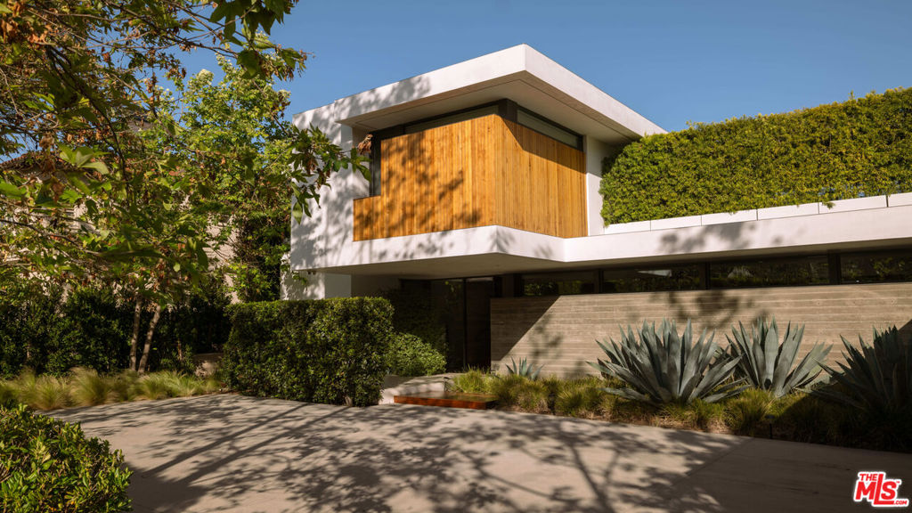 Nestled in the highly sought-after Riviera neighborhood of Pacific Palisades, 748 Amalfi Drive offers a masterful blend of bold architectural design and refined luxury. This California Modern estate, completed by renowned firm O+L, spans three expansive levels and is thoughtfully designed to harmonize with its lush surroundings, creating a seamless connection between indoor comfort and outdoor living. With nearly 9,000 square feet of interior space, this home provides six spacious bedroom suites and eight elegant bathrooms. As you enter, a dramatic cantilevered entryway and floating staircase framed by a soaring concrete feature wall set the tone for the home's striking aesthetic. Inside, clean lines, open living areas, and walls of retractable glass allow natural light to flood the space, offering unobstructed views of the beautifully landscaped grounds. The kitchen is a chef's dream, featuring sleek cabinetry, high-end Miele appliances, and a large central island perfect for entertaining. Additional features include a private home theater, a temperature-controlled wine cellar, a sauna, and a sophisticated home office, ensuring every modern convenience is within reach. The primary suite is a private sanctuary, complete with its own fireplace, dual spa-like bathrooms, a custom walk-in closet, and direct access to a serene balcony overlooking the backyard. Outside, the home transforms into a resort-like retreat with a sparkling pool and spa, a spacious outdoor dining area, and a manicured lawn ideal for entertaining or relaxing under the California sun. Surrounded by mature landscaping for privacy, this home is a rare offering in one of Los Angeles' most prestigious enclaves. With inspired design, thoughtful amenities, and a location that's second to none, 748 Amalfi Drive is modern coastal living.