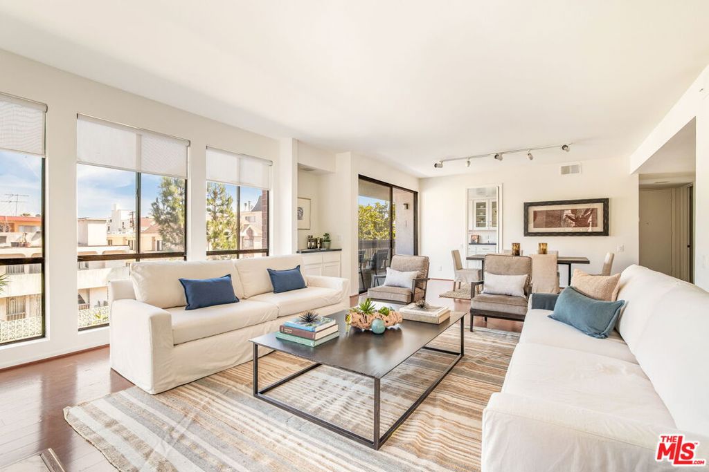 Experience the best of Westside living in this light-filled corner-unit condo nestled in the heart of Brentwood. Designed for both style and comfort, this two-bedroom, two-bathroom residence boasts a thoughtfully remodeled interior with refined finishes throughout. An airy, open-concept floor plan is enhanced by warm wood floors and abundant natural light streaming through expansive windows. The spacious living room features a stone fireplace, a wet bar for effortless entertaining, and access to a covered balcony -- ideal for morning coffee or evening wine. The dining area flows seamlessly into the kitchen, where bright white cabinetry and tiled backsplash contrast against dark stone countertops. Stylish as it is functional, the kitchen includes a pantry, stainless steel appliances, and a charming breakfast nook. Two generously-sized bedrooms act as private retreats, with the primary suite featuring two walk-in closets and a spa-inspired ensuite bathroom with dual vanities, a tiled shower with a rainhead faucet, and a separate soaking tub. The second full bathroom has also been remodeled with modern finishes, and an in-unit laundry room adds everyday convenience. Residents enjoy the benefits of a controlled-access building with secure garage parking, including two assigned spaces for the unit. Ideally situated near popular dining and shopping along San Vicente and Wilshire Boulevards, top-rated schools, the Brentwood Country Mart, and just a short drive to the beach, this home combines modern updates and unmatched convenience in one of the Westside's most sought-after neighborhoods.