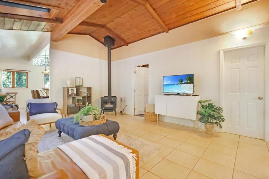 Welcome to this delightful single-story home, conveniently located less than a mile from central Boulder Creek. Nestled in a charming neighborhood surrounded by majestic redwoods, this lovely residence offers a perfect blend of nature and modern living.  The home boasts granite countertops and a gas range in the kitchen, complemented by beautiful tile floors throughout. Skylights fill the space with natural light, and every room offers picturesque views of the redwoods. Enjoy outdoor living on the expansive back deck and spacious yard, ideal for relaxation and entertaining.  Unlike many mountain properties, this home provides all the amenities you expect, including public water and electricity, ensuring convenience and comfort in a stunning natural setting.