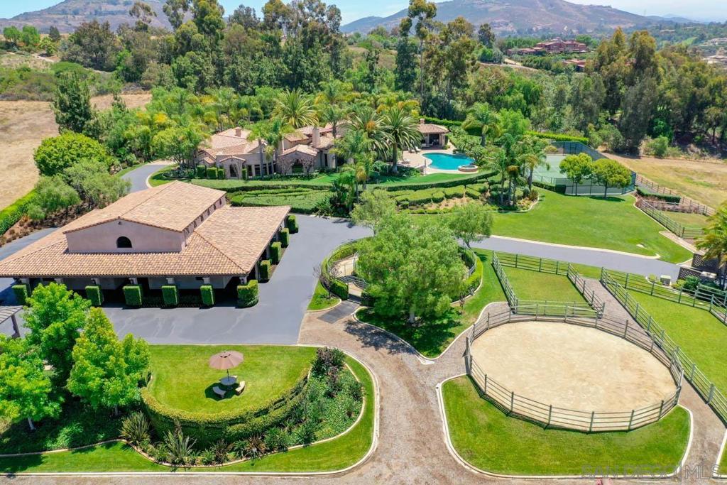 Immaculate equestrian estate with quality custom home includes 7400 sf under roof, outdoor dining and entertaining areas, attached guest house, infinity edge pool, tennis court, raised bed garden area and personal orchard. Gorgeous 9 stall barn with every amenity, huge arena, euro-walker and on site trail. Extremely private location with views over Bridges golf course. Property includes owned solar. Equestrian improvements are truly exceptional. Ride on dedicated Encinitas trails for 30 miles and beyond. Location is extremely quiet and private, yet is close to restaurants, retail and beaches with cool, coastal breezes.