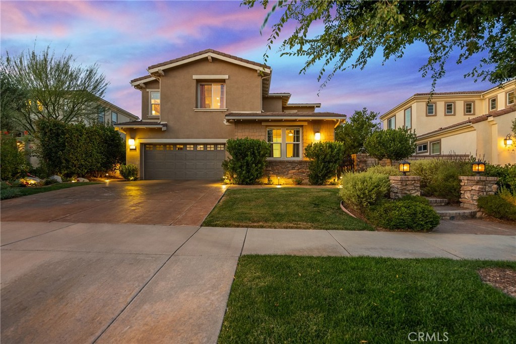 Spectacular View Home in the Gated Valencia West Hills Community!
Nestled on a quiet cul-de-sac in the highly sought-after Iron Village enclave of Valencia West Hills, this stunning residence offers luxury living with a designer’s touch and breathtaking views of the valley. Featuring 4 bedrooms (including one full bedroom with en-suite bathroom downstairs with private exterior access), 4.5 bathrooms, and a spacious upstairs loft, this home seamlessly blends function and elegance.
Step inside to discover wood-like tile flooring, custom lighting, and crown molding throughout the main level. The heart of the home is a chef’s dream kitchen with an oversized island, butler’s pantry with wine fridge, and reverse osmosis water system plumbed to both the kitchen sink and refrigerator. The open-concept design flows effortlessly into the living room, where built-in surround sound creates the perfect space for movie nights or entertaining.
Upstairs, the luxurious primary suite boasts dual walk-in closets with custom built-ins, dual vanities, a walk-in shower, soaking tub, and a private balcony offering panoramic views of the valley. Two additional bedrooms, two full bathrooms, a versatile loft, and an upstairs laundry room complete the second floor.
Step outside to enjoy true Southern California living with a beautifully landscaped yard featuring low-voltage lighting, underground drip irrigation, stamped concrete, courtyard and backyard fountains, a built-in BBQ with fire feature and seating, and a covered patio with ceiling fans—all designed for year-round enjoyment.
Community amenities are second to none, including three pools and a spa, tot lot, basketball and sports court, and lush community parks. Plus, enjoy easy access to the picturesque paseos that wind throughout the neighborhood.
This home checks every box—gated community, cul-de-sac location, valley views, and upgraded finishes throughout. Come experience the best of Valencia living!