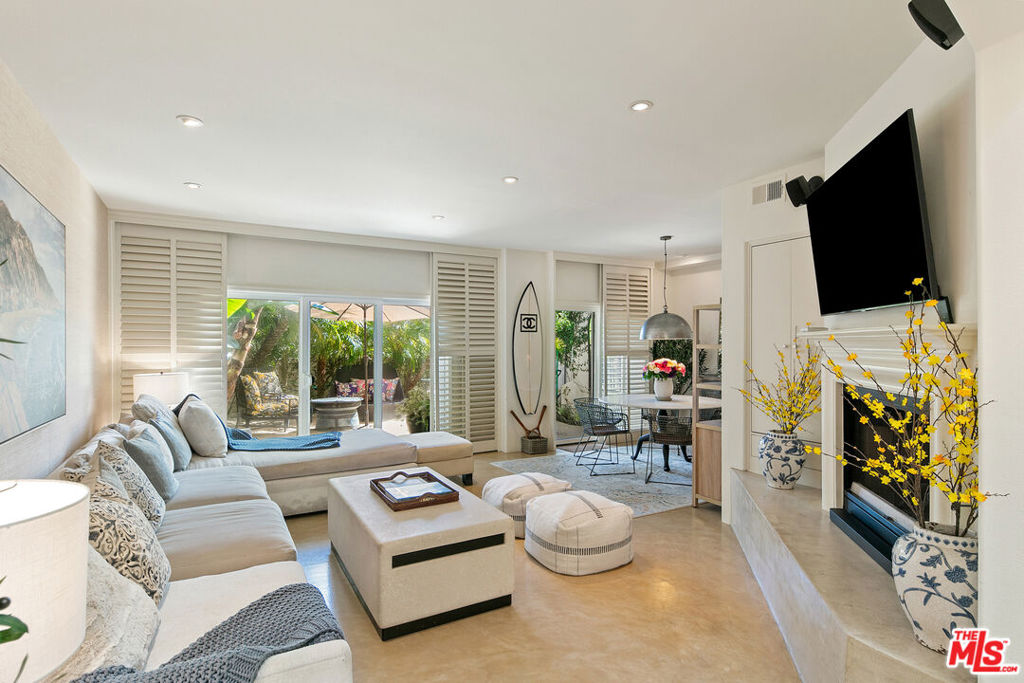 Welcome to Portico, one of Malibu's more intimate and coveted gated enclaves, featuring just 21 residences, a sparkling heated saltwater pool, BBQ area, and a spacious outdoor dining pavilion. Perfectly situated near Point Dume Village and some of Malibu's most pristine beaches, this Mediterranean-inspired community blends elegance with coastal charm. This two-bedroom Townhome offers a seamless indoor-outdoor lifestyle. The spacious living room showcases polished concrete floors, a cozy fireplace, and direct access to a lushly landscaped patio ideal for entertaining or unwinding in privacy. The dining area flows naturally into this tranquil outdoor space, enhancing the open-concept feel. Upstairs, the large primary suite is a true retreat with its own fireplace, generous closet space, and a private covered balcony overlooking scenic Point Dume. The guest bedroom includes a private balcony as well, offering ocean breezes and natural light. Additional highlights include a two-car attached garage and easy access to Malibu's best shops, dining, and beaches.