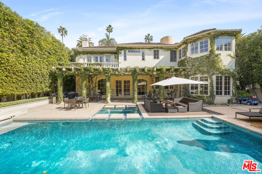 Gated Mediterranean estate in the prime Beverly Hills flats. This exceptional residence features over 7,100 square feet of living space comprised of 7 bedrooms and 9 bathrooms on an over 11,000 sq ft lot. A 2-story foyer opens to a formal living room with a fireplace and ceiling-high French windows. The large formal dining room is served by an enormous butler's pantry designed for entertaining. This leads to a well appointed gourmet kitchen with tons of counter space, featuring a professional Viking gas range, 2 sinks, 2 dishwashers, a double oven and an additional cooktop. The attached breakfast room has ample space for intimate meals while overlooking the backyard waterfall, pool and spa. The family room features a wet bar and an additional gas fireplace. Also complementing the first floor is a separate wood-paneled office with built ins, and a maids quarters. Downstairs there is a huge basement with a functional wet bar for additional entertaining, a bedroom, bathroom and additional storage. The upstairs has 5 large en-suite bedrooms. The primary suite is over 1,000 square feet and has its own cozy fireplace, a built-in fish tank, 2 bathrooms, walk-in closets, and a balcony. Come discover this extraordinary home on Hillcrest which is known for its beautiful palm trees and historic luxury estates.