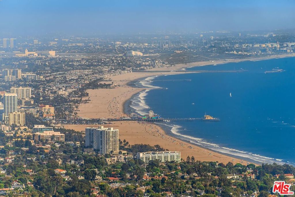 One of a kind Modern Shangrila with Panoramic Ocean, City & Mountain Views from Downtown Los Angeles to The Santa Monica Pier & Catalina Island. Exquisite, handcrafted resort-like property with impeccable attention to detail in design. A sophisticated foyer leads to an expansive great room with unique wood & stone finishes that opens on all sides to the private lush grounds, Balinese style infinity pool & breathtaking views. Large open kitchen with marble counters & sub Zero & Miele appliances. Spacious master suite opens to the pool & views with spa like bathroom with an elegant black granite tub & double showers surrounded by greens and views. Spacious detached guest house with living room, kitchenette, bedroom, bathroom with shower and laundry. Beautiful wood finishes surround the patio & grassy yard which include an outdoor sitting area, dining area, built in BBQ & pizza oven. Night sky observation deck & raised vegetable beds are just a few of other added features.