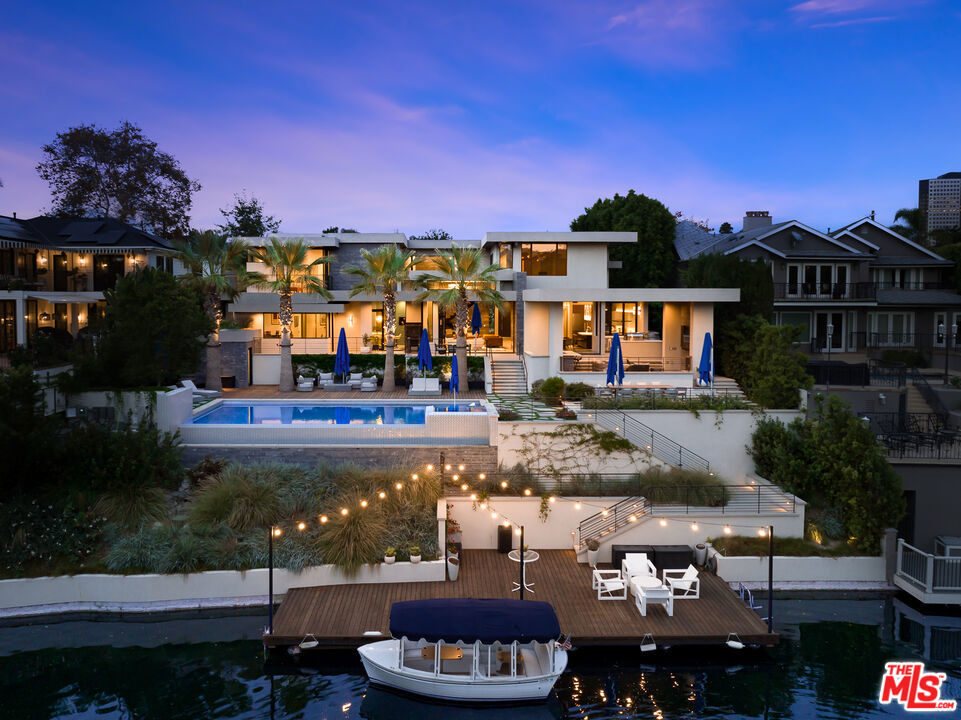 Sold before processing. Listed for comparable purposes only. Welcome to 10050 Toluca Lake Ave, a modern and custom-designed masterpiece perfectly situated in the heart of the coveted Toluca Lake neighborhood. This extraordinary home offers not just a place to live, but a lifestyle on the tranquil Toluca Lake itself. As you step inside, you are immediately greeted with breathtaking views of the lake. The main floor is bathed in the soft glow of the sun reflecting off the water, boasting a generous kitchen with an inviting breakfast area, ideal for enjoying your morning coffee. The lounge in the front room, complete with a wine closet, adds to the entertainment options and offers a cozy retreat for relaxation and enjoyment. The dining room offers a perfect setting for memorable gatherings. This home has been thoughtfully designed with your comfort and convenience in mind, featuring an elevator for easy access to all levels. As you ascend to the second floor, you'll find a luxurious primary suite complete with separate closets and spectacular lake views. Three additional en-suite bedrooms offer privacy and comfort for your family and guests. A laundry room adds to the ease of your daily routine. The basement of this home is an entertainment haven, featuring a theater for enjoying your favorite films in style. A playroom/den with a convenient kitchenette provides a space for relaxation and fun. An en-suite bedroom offers a private retreat, and a powder room adds convenience for your guests. With a total of 5 en-suite bedrooms, 2 offices, 6 full baths, and 4 half baths, including a pool bath, this home ensures that every member of the household has their own space and privacy. Additionally, one of the offices can easily be converted into a 6th bedroom to further accommodate your needs.Outside, you'll find a covered patio, perfect for embracing the California weather year-round. The meticulously landscaped grounds offer a private escape, all while being right on the water's edge. Plus, there's an infinity pool where you can take in the best views of the lake and enjoy the fireworks during special occasions.Situated in the desirable neighborhood of Toluca Lake, this home offers not just a residence but a retreat. Your days on Toluca Lake can be filled with leisurely boat rides on your Duffy boat, or simply basking in the beauty of the surroundings while watching the sunset. With this prime location and the serene embrace of lake living, this home is an opportunity to create the ultimate story of waterfront living.