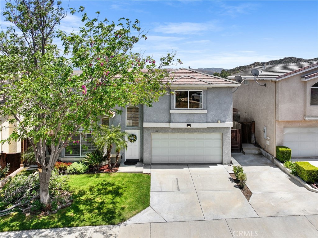 Step into this inviting 4-bedroom, 2 ½-bathroom detached home, ideally located in the highly sought-after Castaic Oaks neighborhood just off Parker Road. Bathed in natural light, this home features a spacious, open layout with soaring vaulted ceilings. Upon entry, you’re greeted by a stunning custom wrought iron staircase, adding an elegant touch and setting the tone for the rest of the home. The main level boasts beautiful flooring, crown molding, a cozy fireplace, and a versatile bonus room that can be used as a formal dining area, home office, or den. The kitchen is equipped with granite countertops, stainless steel appliances, a designer tile backsplash, a breakfast bar, and a walk-in pantry, all flowing seamlessly into the family room with a built-in entertainment center and direct access to the backyard. Step outside to a private, low-maintenance yard featuring a covered California room and a spacious patio, perfect for relaxing or entertaining. The community pool is just steps away, providing the perfect escape on warm summer days. Upstairs, the expansive primary suite offers a walk-in closet and an en-suite bath with dual sinks. Three additional bedrooms provide ample space, natural light, and scenic views. A full guest bathroom is conveniently located upstairs, and there’s also a guest powder room on the main floor. Additional features include an attached 2-car garage with direct access and in-garage laundry. The low $180/month HOA fee covers water, front yard maintenance, and access to the community pool and spa. Located just minutes from Castaic Lake, top-rated schools, parks, and major commuter routes, this home is an exceptional find in a prime community. Come see it for yourself and envision your future here!