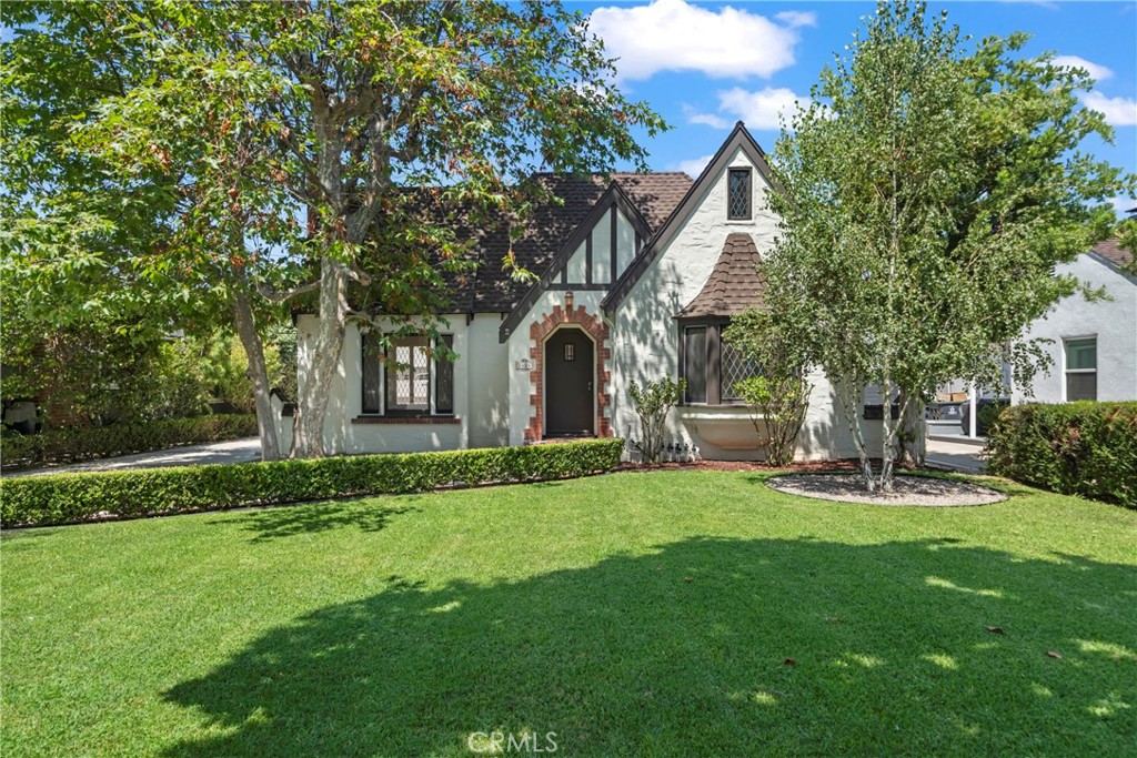 Fully remodeled and highly upgraded elegant 1930 Tudor Gem on Poinsettia Street. Discover a remarkable opportunity with this residence, nestled in the charming neighborhood of Santiago Park, Santa Ana. This captivating 4-bedroom, 3-bathroom home boasts 2,070 square feet of elegantly designed living space, set on a generous 8,360 square foot lot. As you step into this prestigious tree-lined street, you'll be enchanted by the beautiful streets filled with vintage custom homes. The house welcomes you with a large open floor plan, enriched with abundant natural light and an inviting atmosphere. The main level features a full suite bedroom, perfect for guests or multi-generational living, while the upper floor accommodates additional private retreats. The heart of this home is its gourmet kitchen, equipped with high-end chef appliances, including a wine fridge, catering to all your culinary adventures. The beautiful dining room seamlessly opens onto a large paved patio, ideal for outdoor dining and entertaining. Relax and unwind in the spacious family room or enjoy leisure activities in the media room, perfect for kids to play or watch TV. Beyond the interior, the meticulously landscaped backyard is a true sanctuary. It features an outdoor kitchen and fireplace, surrounded by mature fruit and citrus trees, offering a private oasis for relaxation or entertaining. The very large backyard holds potential for an Accessory Dwelling Unit (ADU), adding tremendous value and versatility to the property. Additional amenities include a washer/dryer in-unit, air conditioning, and parking for both everyday vehicles and RVs. The property also features a 2-car garage with attic storage, a very long driveway, and a generously sized basement storage room. Embrace the best of both worlds with a lovely neighborhood ambiance and the convenience of great entertainment close by. Santiago Park, recently renovated with new paths and play areas, provides an idyllic setting for outdoor activities and community gatherings. Seize this rare opportunity to own a piece of architectural elegance with modern amenities in one of Santa Ana's most desirable neighborhoods.