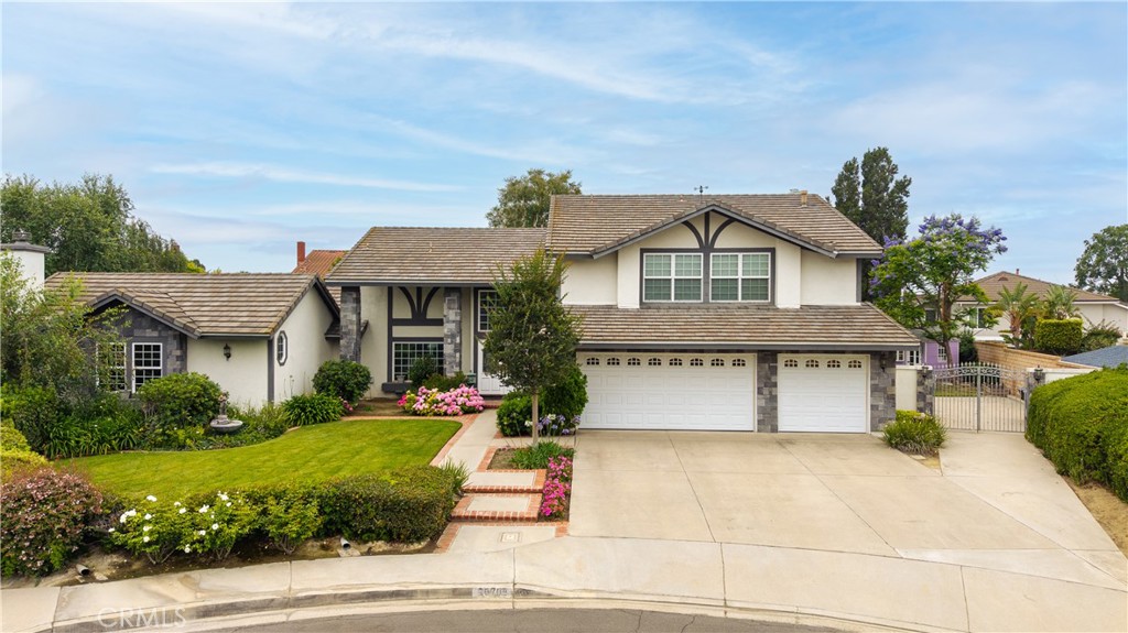 Welcome to this stunning 4-bedroom, 3.5-bath estate nestled on a cul-de-sac in Yorba Linda’s highly desirable Travis Ranch community. From the moment you arrive, you’ll be captivated by the home’s impressive curb appeal, elegant design, and peaceful surroundings. The main level welcomes you with a formal entryway leading to the sophisticated living and dining areas. The upgraded kitchen features custom cabinetry, granite countertops, KitchenAid appliances - including double ovens, a gas top 5-burner range, a built-in refrigerator, lighted cabinetry, and a coffee bar off the kitchen. The kitchen opens seamlessly to the inviting family room with a cozy fireplace and an adjacent powder room for guests. A true highlight of the home is the expansive first-level bonus room, featuring soaring ceilings, a custom fireplace, a cherry wood wet bar, and double doors that open to a tranquil backyard haven. This well-designed bonus space offers a seamless indoor-outdoor flow—perfect for both entertaining and relaxing. Steps away, you’ll find an additional bathroom and built-in lower cabinetry for added convenience and storage. Outside, enjoy an in-ground heated pool with a tranquil waterfall grotto and pebble tec pool finish. The lush, professionally landscaped yard includes mature trees for privacy, a spacious grassy area, a covered patio, and a playhouse for the little ones. Upstairs, the spacious primary suite offers high ceilings, a beautifully updated en-suite bathroom with quartz countertops, designer tile backsplash, and dual vanities. Three additional bedrooms located on the 2nd level and an office - easily convertible into a fifth bedroom —offering flexibility for family, guests, or work-from-home needs. The upgraded 2nd level guest bathroom features custom cabinetry and granite countertops. Ideally located in a quiet, established neighborhood, this exceptional home is just moments from award-winning schools, parks, dining, and shopping. Don’t miss your chance to own a piece of luxury in Yorba Linda’s prestigious Travis Ranch!