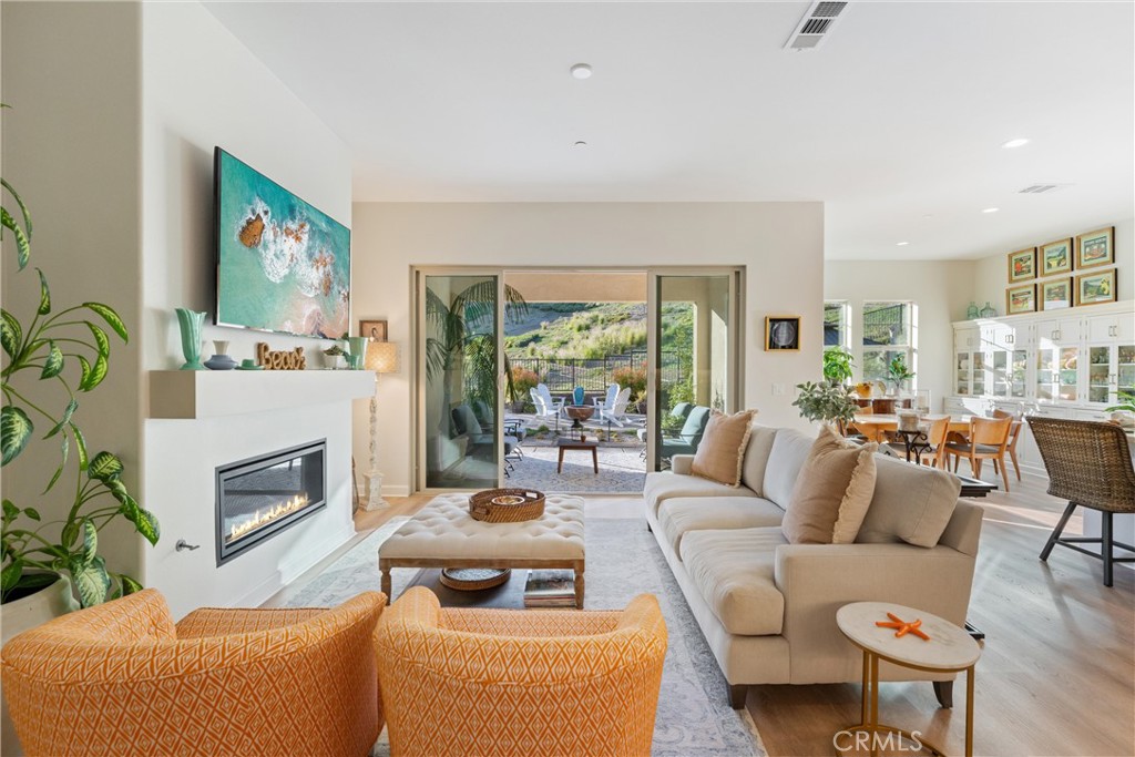 55+ RESORT-STYLE LUXURY LIVING | 1-STORY | PANORAMIC VIEWS | FULLY PAID SOLAR | GUARDED + GATED | Welcome to this beautifully upgraded home in the highly desired Terramor — where modern luxury and comfort meet in a vibrant community! A welcoming front patio with mountain views sets the stage for easy living in this elegant residence. Step inside to be greeted by abundant natural light, gorgeous luxury plank flooring, & an impressive array of upgrades. The open-concept Living Room has a warming fireplace & a 2-panel sliding glass door that extends your living space into the grand California Room & fully landscaped yard, creating the perfect blend of indoor-outdoor living. The chef-inspired Kitchen boasts stunning quartz countertops, breakfast bar seating, upgraded cabinetry, stainless steel appliances, pot & pan drawers, under-cabinet lighting, and oversized walk-in pantry. The Dining Room offers convenience for entertaining with a second slider to the backyard & a built-in china hutch with glass display doors—adding style & function. The Primary Ensuite Bedroom is spacious & filled with natural light, creating a serene retreat. The spa-like Ensuite Bathroom showcases quartz countertop, dual sinks, an oversized frameless shower with seating, upgraded cabinetry, & a walk-in closet with custom built-ins. Bedroom #2 enjoys stunning mountain views, while the Builder's spacious optional Bedroom #3 is currently a combined office/den. Bathroom #2 includes quartz counters and a shower-tub combination. Additional highlights include a separate Laundry Room with extended cabinetry and utility sink, and a Mudroom featuring a custom upholstered bench and extra entry storage for convenience. Step outside to your private backyard retreat, complete with a covered California Room, firepit with dedicated gas line, gazebo-covered dining area, a 2nd gas line for your BBQ, an oh-so-perfect lavender garden, and captivating sunset panoramic views. Energy efficiency is top-of-the-line with fully paid solar system, EV outlet, tankless water heater, whole house fan, drip irrigation & recessed lighting. Amenities include 2 clubhouses (55+ Only and All Ages), indoor & outdoor pools, fitness center, wellness studio, tennis, pickleball, miles of trails, dog parks & sports fields. Nearby find shopping, restaurants, cinemas & quick access to OC via 15/91 Expressways & 241 Toll. This remarkable residence offers the perfect blend of elegance, privacy, & modern comfort — welcome home!