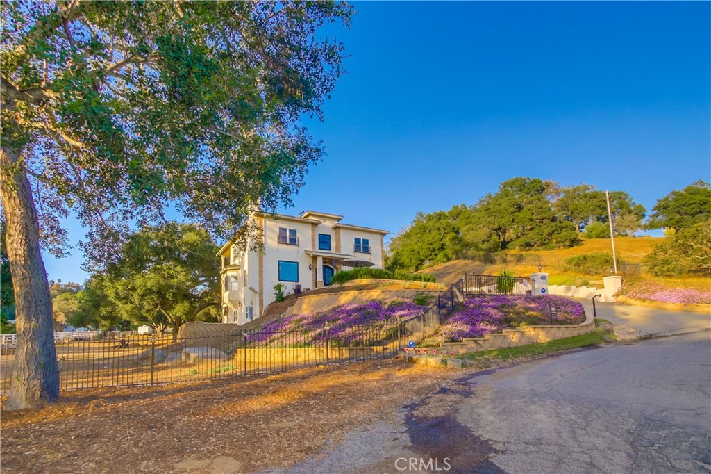 NON CONTINGENT OFFERS ONLY. Nestled in the heart of Gird Valley, a trending & sought-after location, this exceptional luxury estate home offers a lifestyle of unparalleled elegance & sophistication. Surrounded by breathtaking views of Monserate Winery, majestic mountains & captivating sunsets, this gated property welcomes you to a world of refined living. Situated on over 1.5 acres of picturesque land, this property boasts an abundance of outdoor space, including expansive balconies that overlook the serene landscape of rustic oaks and lush greenery. The main residence spans 3,900 square feet of meticulously designed living space, complemented by a finished basement/ADU of 900 sf, providing ample room for extended family living or multi-generational arrangements. Step into the chef's gourmet Island kitchen, adorned with exquisite quartz countertops, a SubZero refrigerator, Wolf 6 burner gas stove, hood range, built-in microwave, ice maker & custom backsplash with pot filler. The open-concept floor plan is ideal for entertaining with luxury engineered lifetime wood plank floors flowing seamlessly throughout the home. Upon entering the custom glass & wrought iron front doors, you are greeted by a formal entry, office/den, spacious living room with cozy fireplace & dining room with sitting area & balcony offering panoramic views of Fallbrook valley. The lower level features a large bedroom with balcony, a full bath, an additional half bath & an interior laundry room with access to the garage & backyard patio. Ascend the custom wrought iron & wood staircase to the upper level, where you will find a large bonus room, a bedroom en-suite & a luxurious oversized primary suite. The primary suite offers a romantic balcony, designer paint & window treatments, a retreat area ideal for an office or workout center, an en-suite bath with a garden tub, double sink vanity, and a step-in glass shower. The fully finished basement, accessible from both the main level and its own exterior entrance, offers endless possibilities. With architectural plans in place for a 2 bedroom, 1 bath ADU/junior suite, this space is ready for your personal touch. This property is a true gem, offering a prime location close to freeway access, wineries, shopping & entertainment. With fully fenced acreage, electric entry gate, RV gate, and ample parking, this estate is perfect for hosting events or operating a business. Endless possibilities await at this extraordinary property!