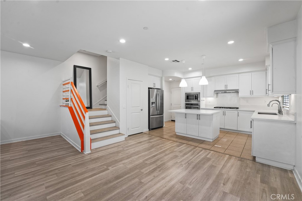 Welcome to this highly upgraded 4-bedroom, 3.5-bathroom townhome nestled in the heart of the sought-after Parasol Park community in Irvine’s Great Park.Spanning approximately 2,480 sqft across three levels, this end-unit offers modern style, comfort, and versatility. The main level boasts sleek laminate wood flooring, a spacious open-concept living and dining area, and a gourmet kitchen with a center island, quartz countertops, stainless steel appliances, pantry, and modern cabinetry. The second floor includes the primary suite with a walk-in closet and spa-inspired bath, plus two additional bedrooms (each with walk-in closets), shared full bath, and a laundry room. A private balcony off the living room provides the perfect spot to unwind. The third floor features a versatile loft, an additional bedroom, and an expansive covered deck, ideal for a home office, guest space, gym, or entertaining with sunset views. Additional features include a 2-car direct-access garage with a high-speed Tesla charger, energy-efficient windows, and abundant natural light throughout. Located just steps from resort-style pools, playgrounds, parks, trails, and top-rated Irvine schools like Cadence Park and Portola High. Conveniently close to Woodbury Town Center, Irvine Spectrum, and major freeways (I-5, 133, 241, and 261), this home truly has it all. Don’t miss your chance to lease this exceptional property!