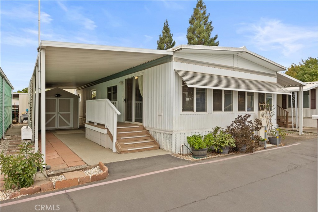 Looking for charm, comfort, and a price that makes you smile? This sweet manufactured home in one of the best senior parks in town checks all the boxes! The open kitchen comes with a fun curved eating bar (perfect for coffee, snacks, or catching up with friends), and the spacious living room is filled with sunshine thanks to all those windows. Every room has a ceiling fan to keep the breezes flowing, and the HUGE 8x16 shed is ready for your tools, treasures, or hobbies. It even has an extended separated section in the rear and its own electricity. And here’s the cherry on top—a great park that exudes community and the lowest space rent in town (which includes trash, water, sewer and use of the pool and clubhouse.) Cute, cozy, safe and affordable…what more could you want?