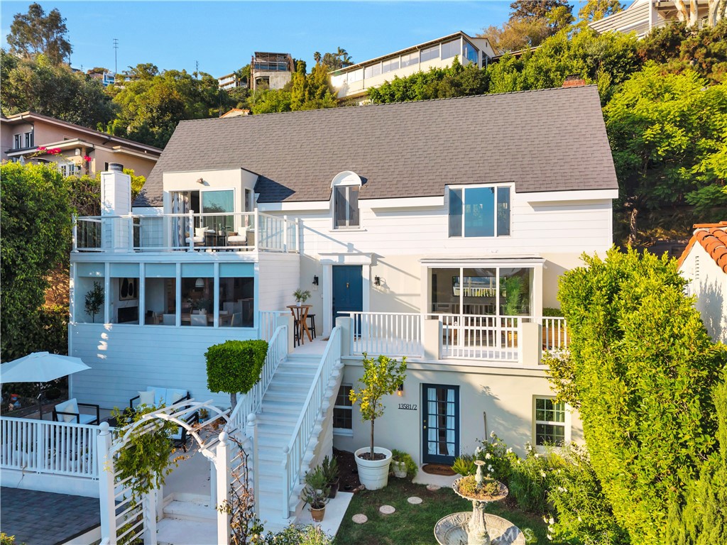 Nestled high above the city’s vibrant rhythm, 1358 Miller Drive is a sanctuary of style, light, and serenity—an artfully reimagined retreat that captures the essence of Hollywood Hills living. Here, modern sophistication meets timeless charm, offering a lifestyle that is both elevated and intimately connected to Los Angeles’ cultural and natural landscape. Set moments from the heart of the city yet enveloped in peace, the home blends quiet luxury with effortless access. A detached guest home with its own entrance and address offers ideal flexibility for guests, staff, creative space, or income. Inside the main residence, a chef’s kitchen with refined stone surfaces and designer finishes anchors the living space, inviting both intimate evenings and lively gatherings. Two expansive primary suites each open to private terraces with sweeping views, spa-like baths, and custom walk-in closets, creating havens of personal retreat. A luminous bonus room offers the perfect setting for an office, studio, or reading nook, while large windows flood the home with natural light. Set back from the street with a grassy front lawn, multiple decks, and a graceful entry, the outdoor spaces offer both privacy and presence. Thoughtfully curated at every turn, this is a home where architecture soothes, light inspires, and daily life unfolds with ease and elegance. More than a residence, 1358 Miller Drive is a rare opportunity to dwell in harmony with design, nature, and the timeless allure of the Hollywood Hills.